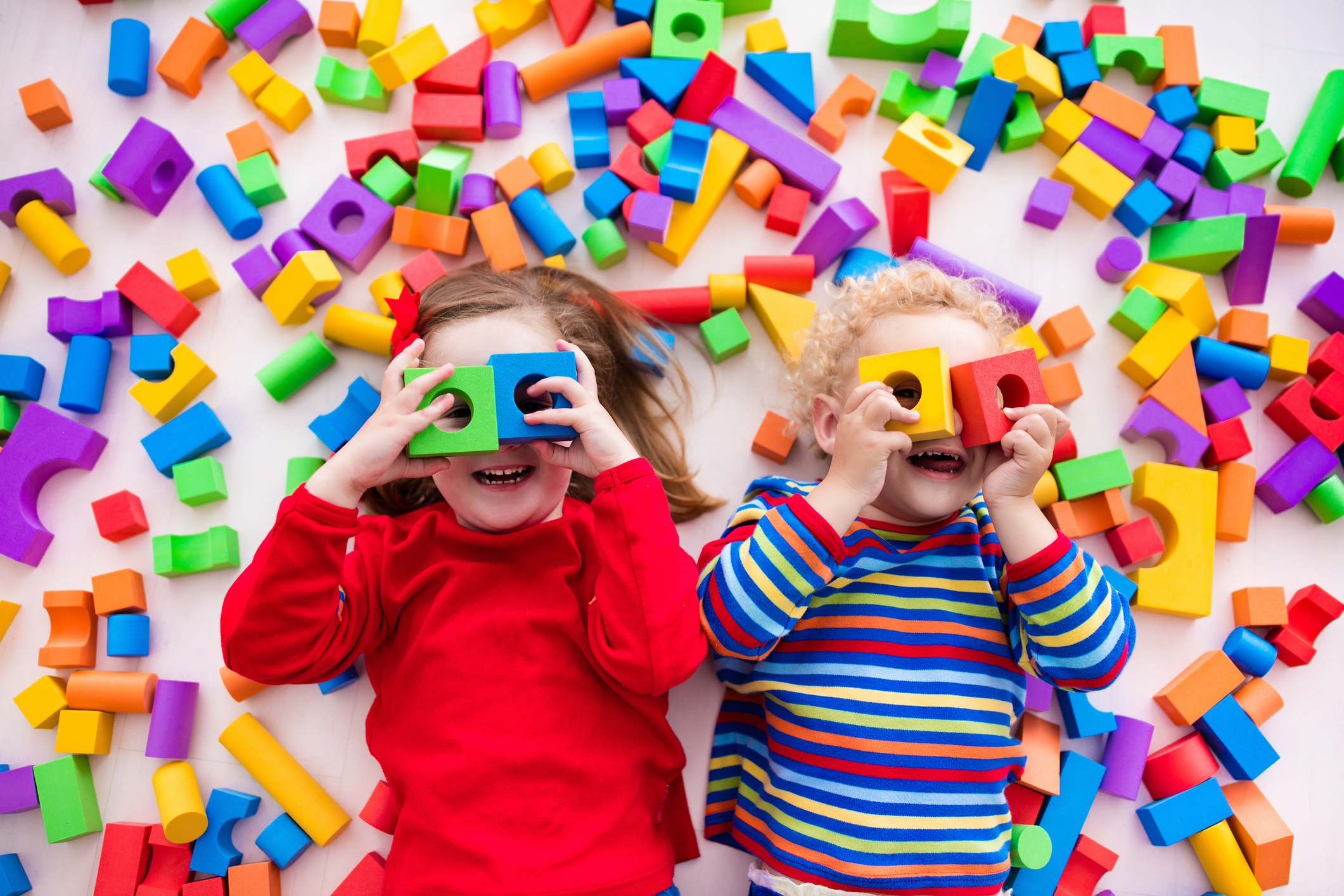 Children playing with colorful blocks building a block tower