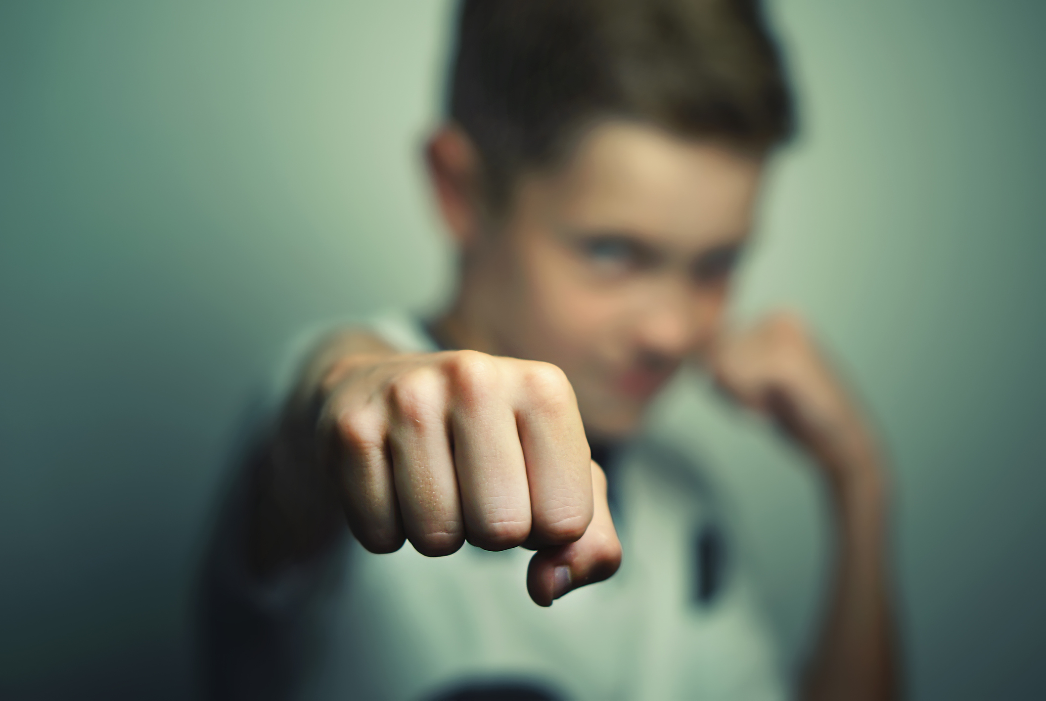 Angry child boy in white t-shirt training box punch.