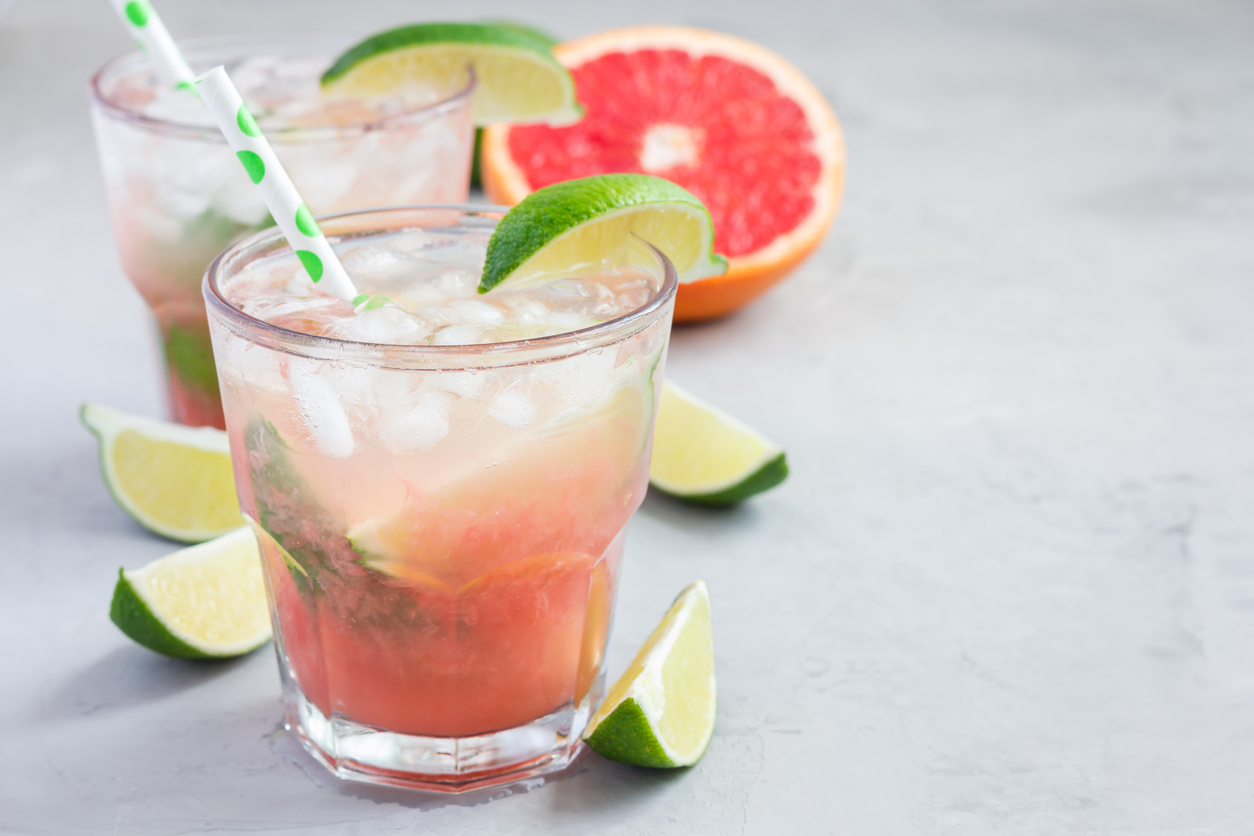 Cold pink cocktail with fresh grapefruit, lime, copy space