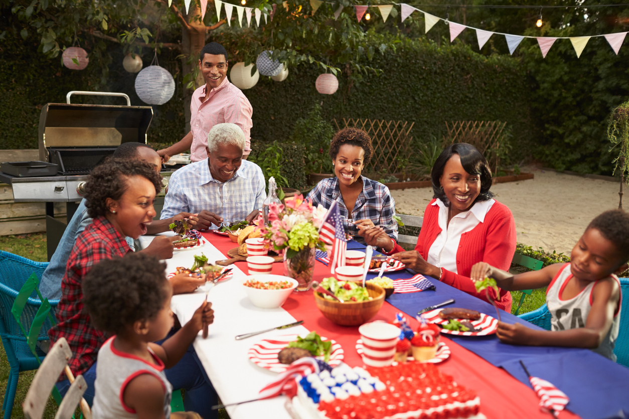 Multi generation black family at table for 4th July barbecue