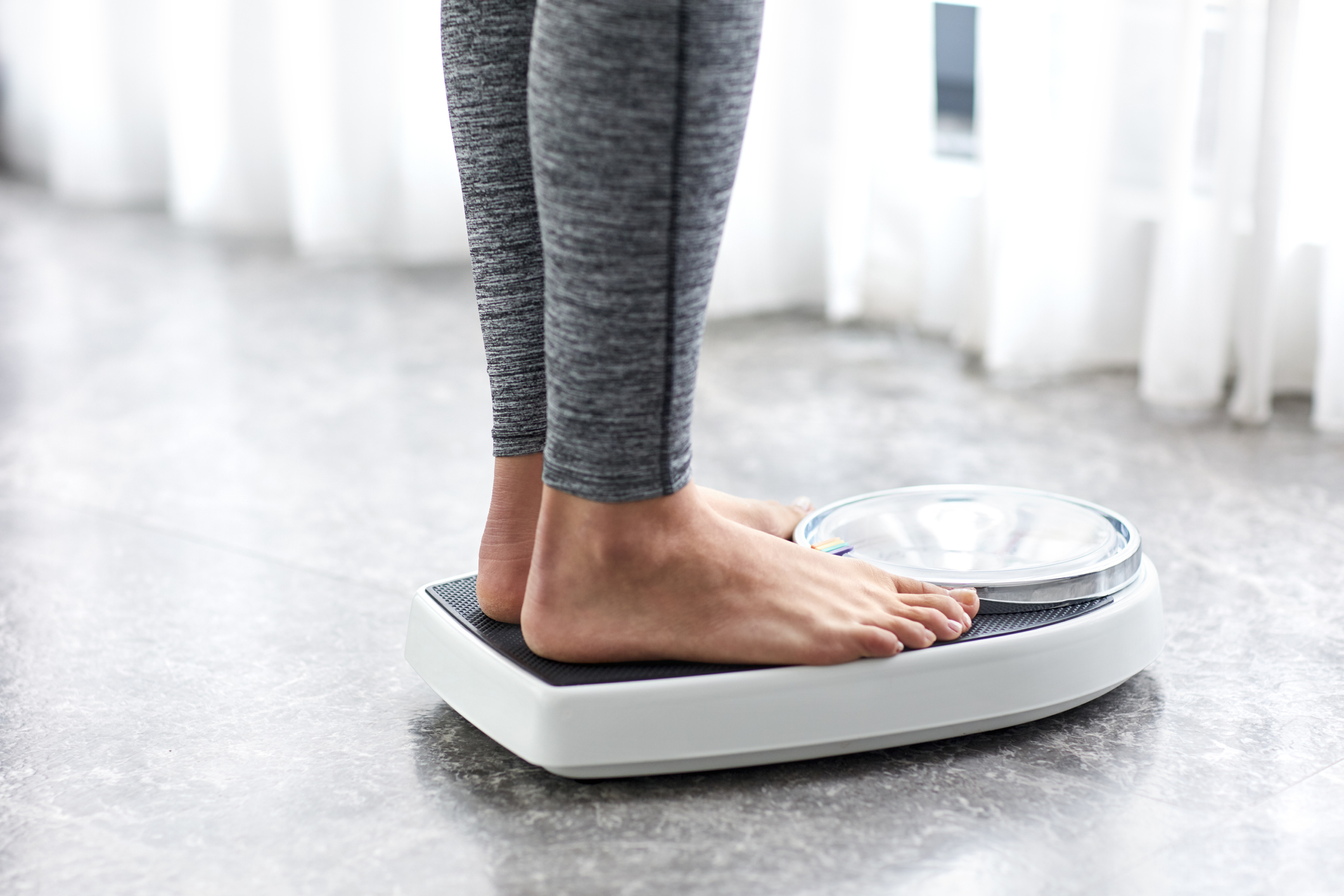 Young healthy girl on home scales