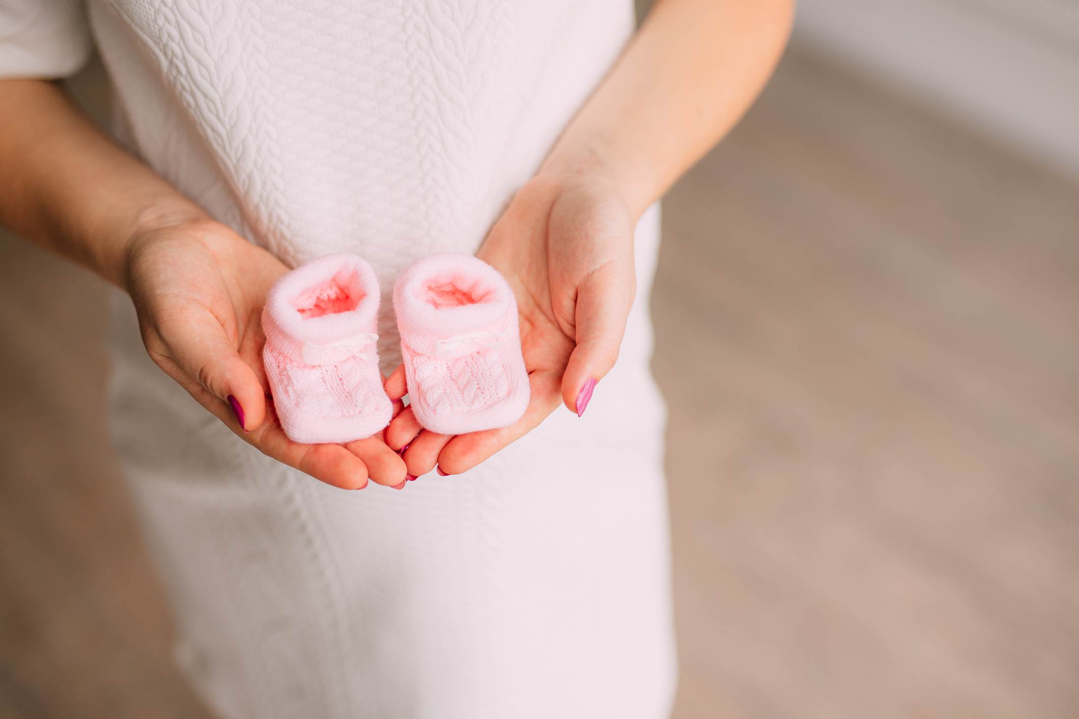 Baby booties in the hands of pregnant mother