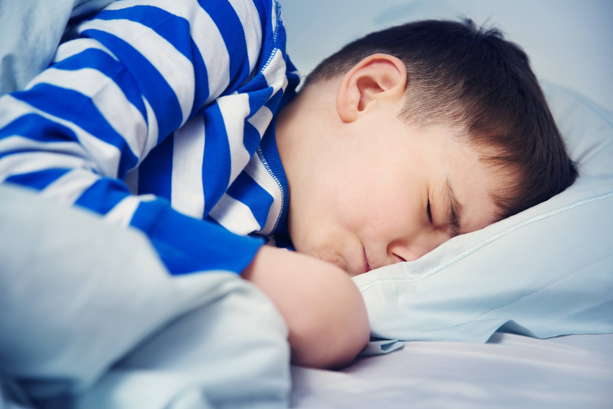 Boy sleeping in bed in pajamas