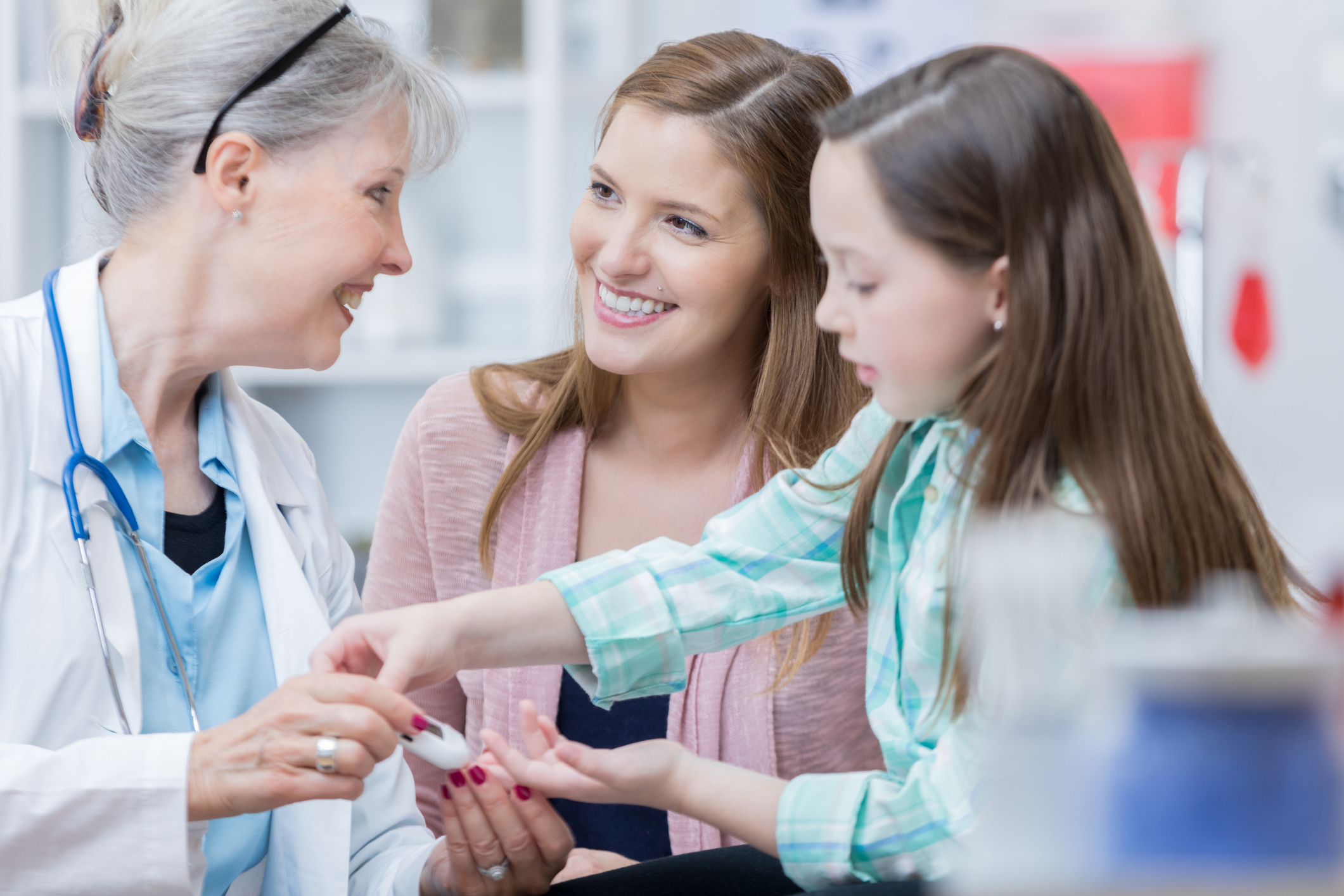 Pediatrician checks young patient's blood sugar levels