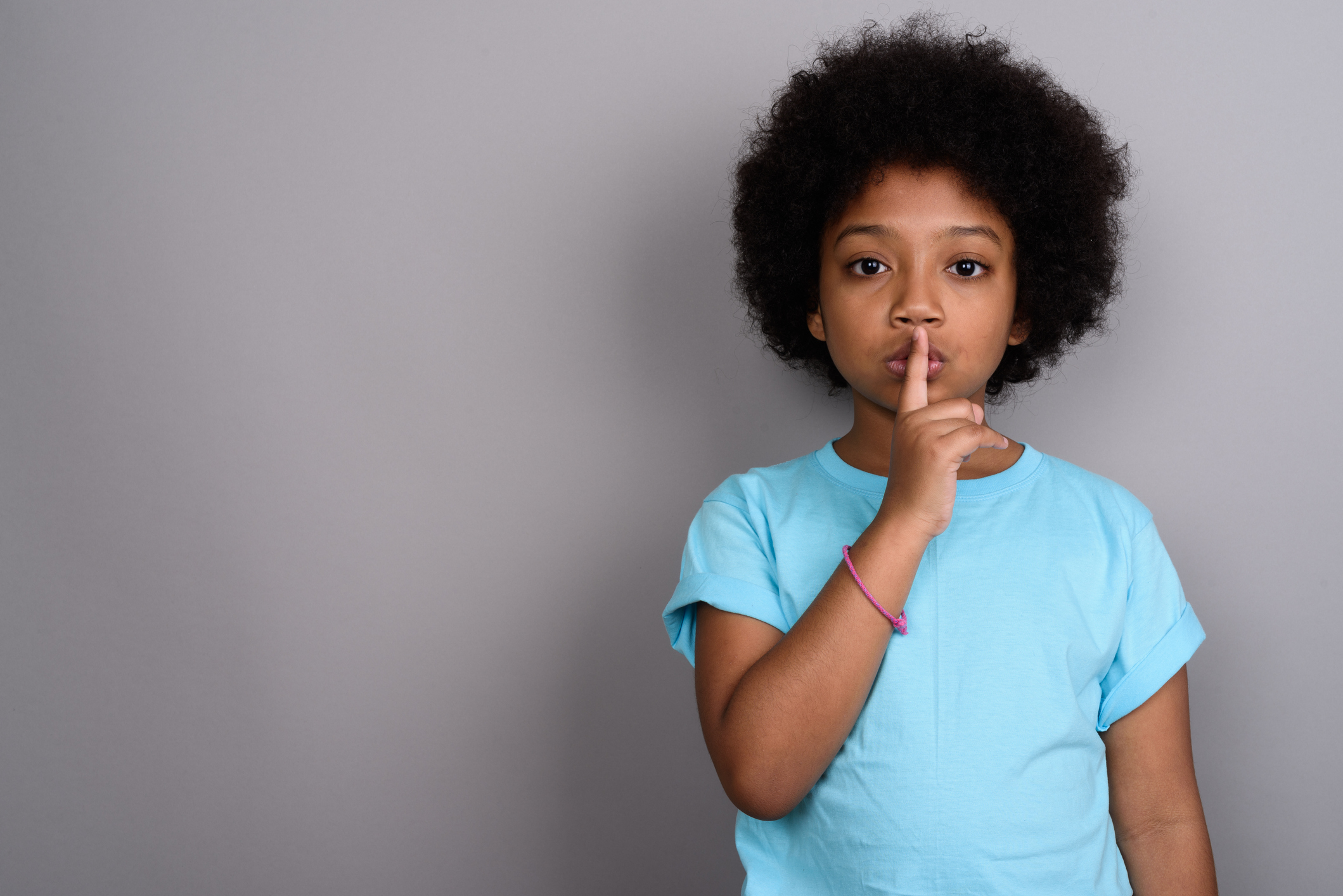 Studio shot of young African girl against gray background