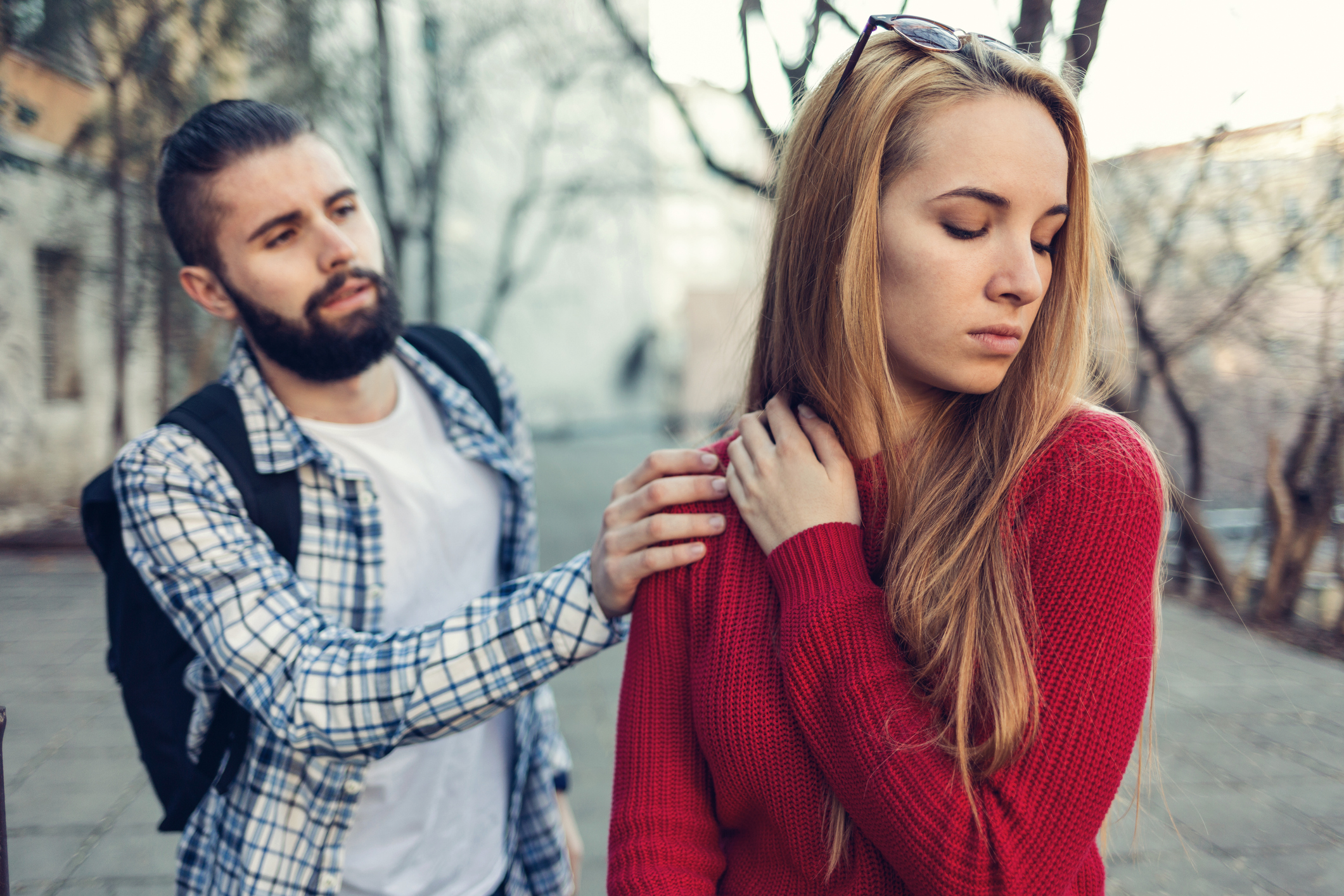 Boy reaching out and touching his girlfriend on the shoulder