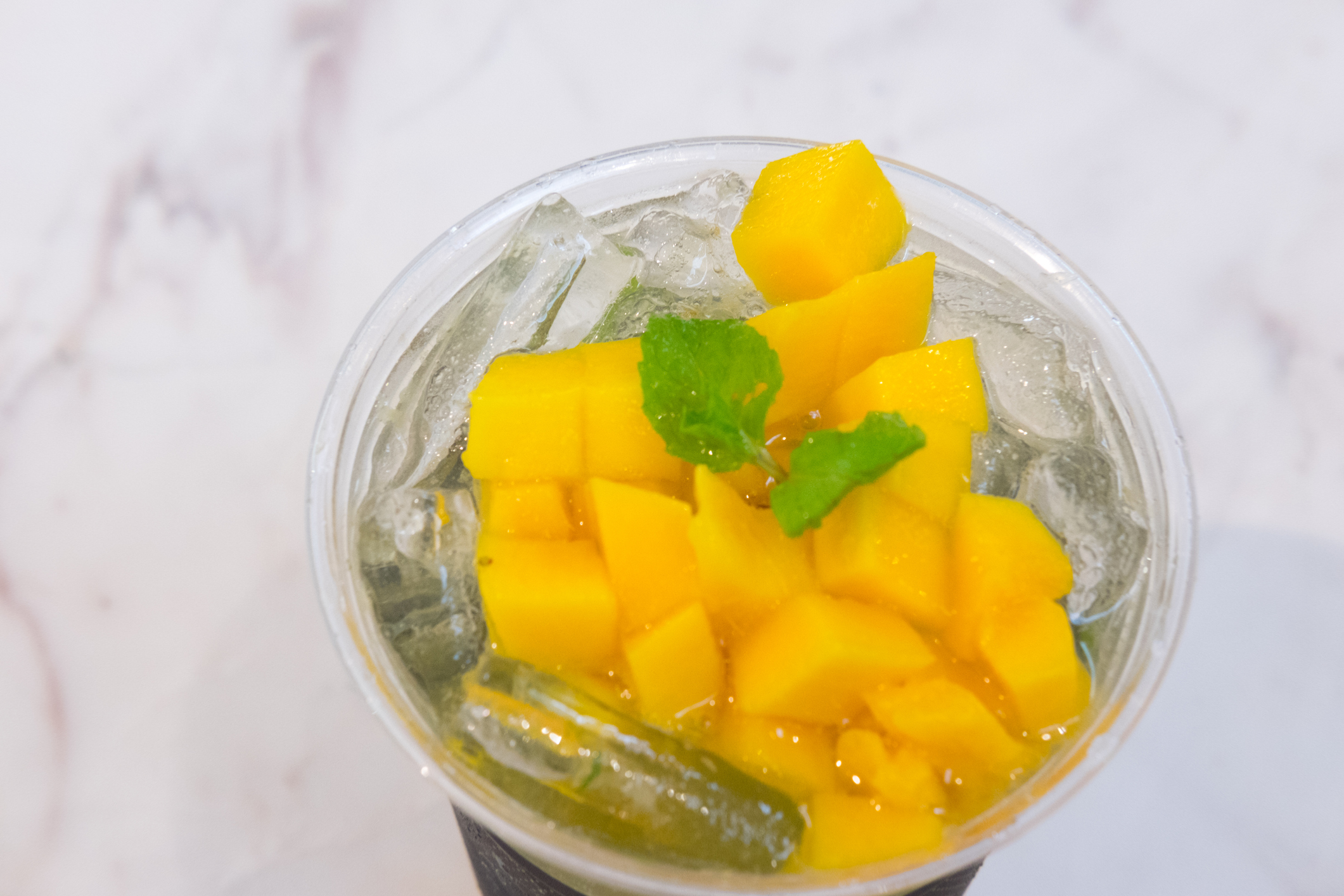 Tropical lemonade with mango slice in glass