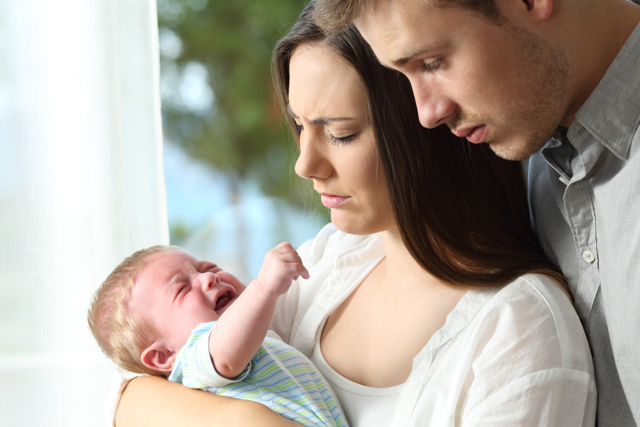 Tired desperate parents and baby crying