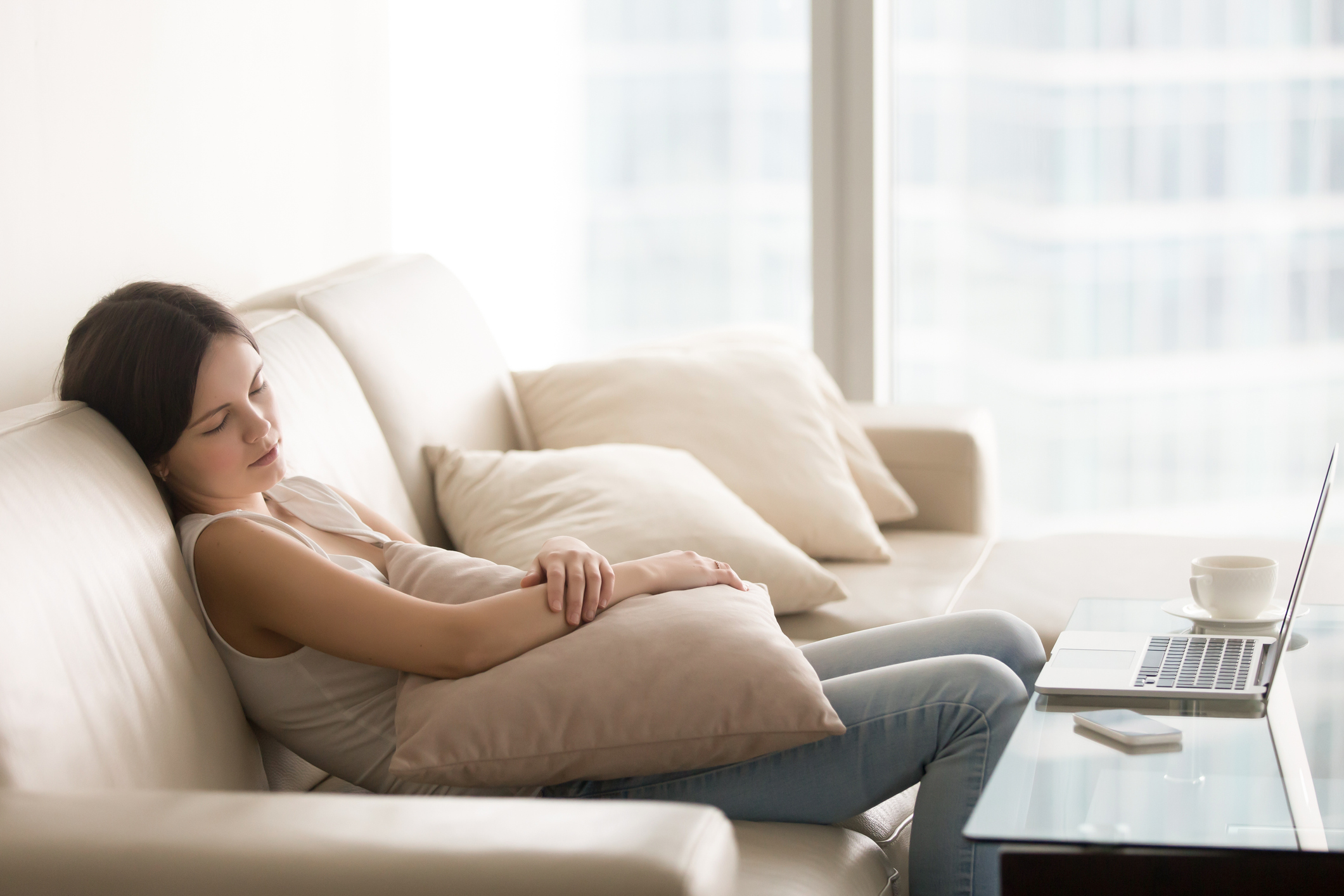 Young pretty woman sleeping on couch, taking nap on sofa