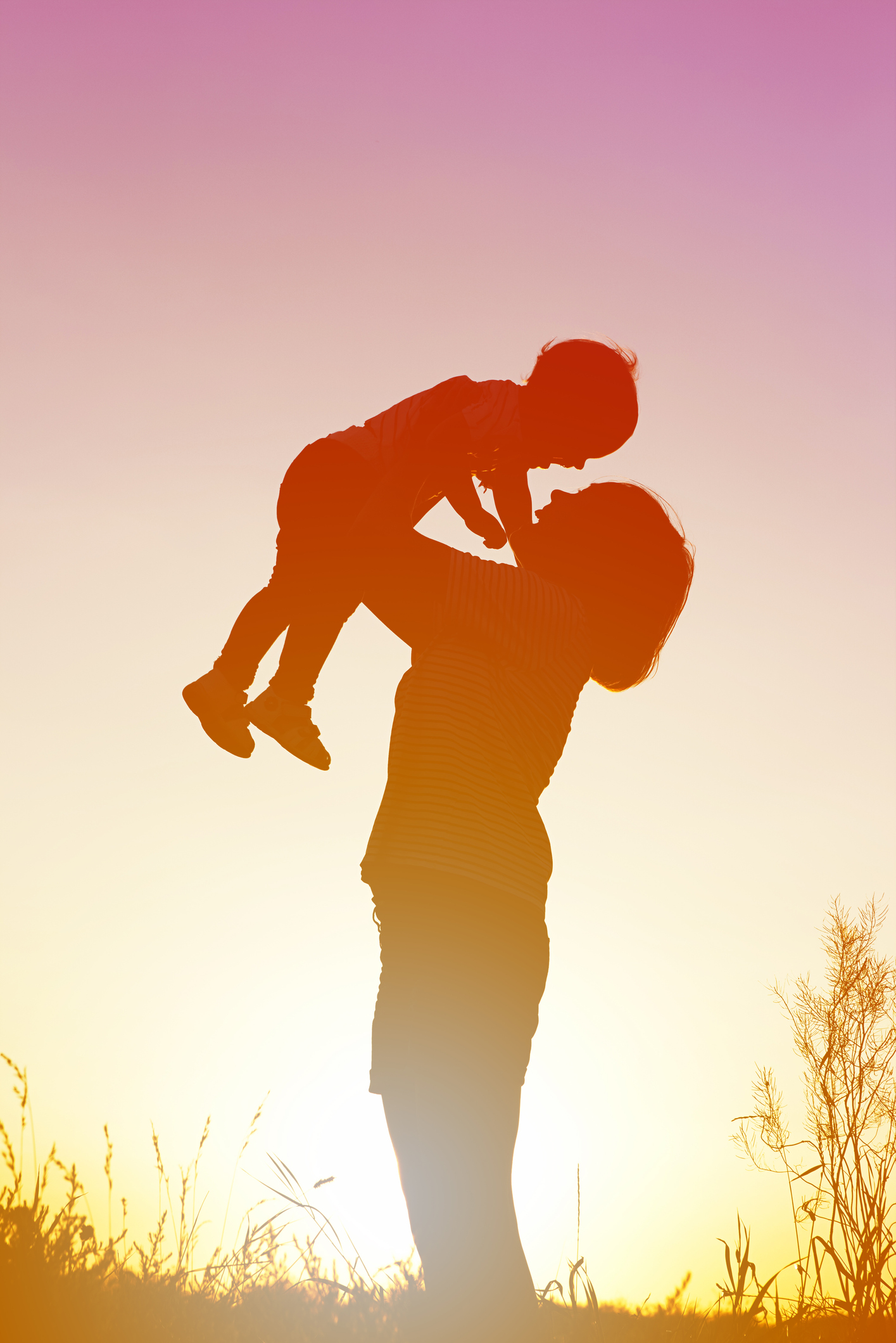 Silhouette of a woman with her child at sunset.