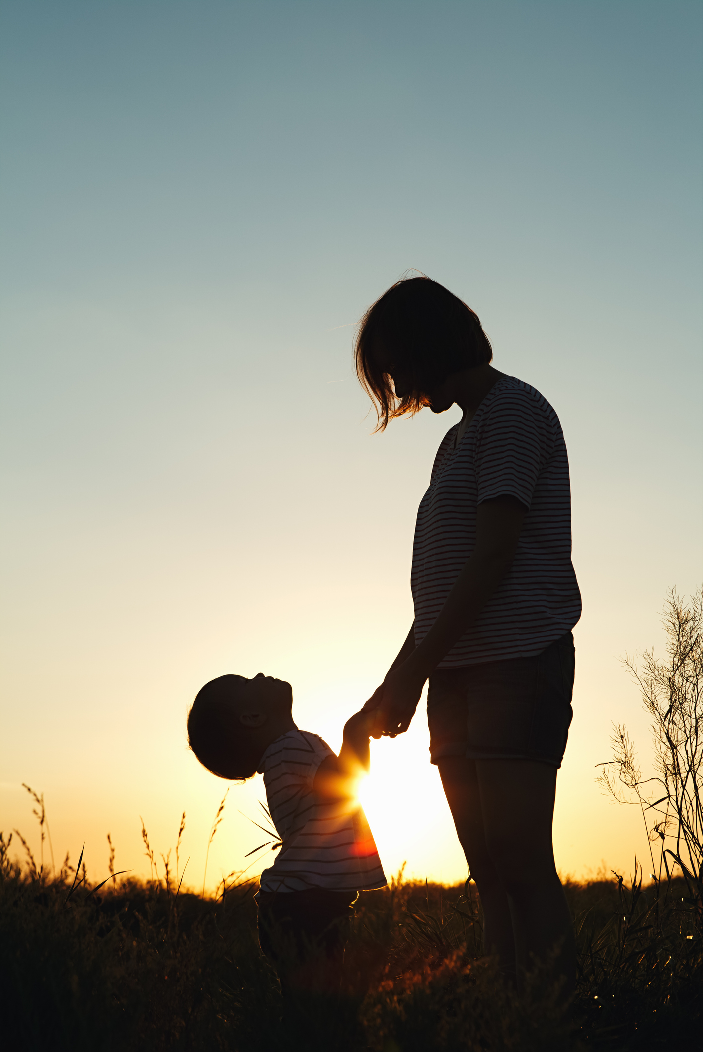 Silhouette of a woman with her child at sunset.