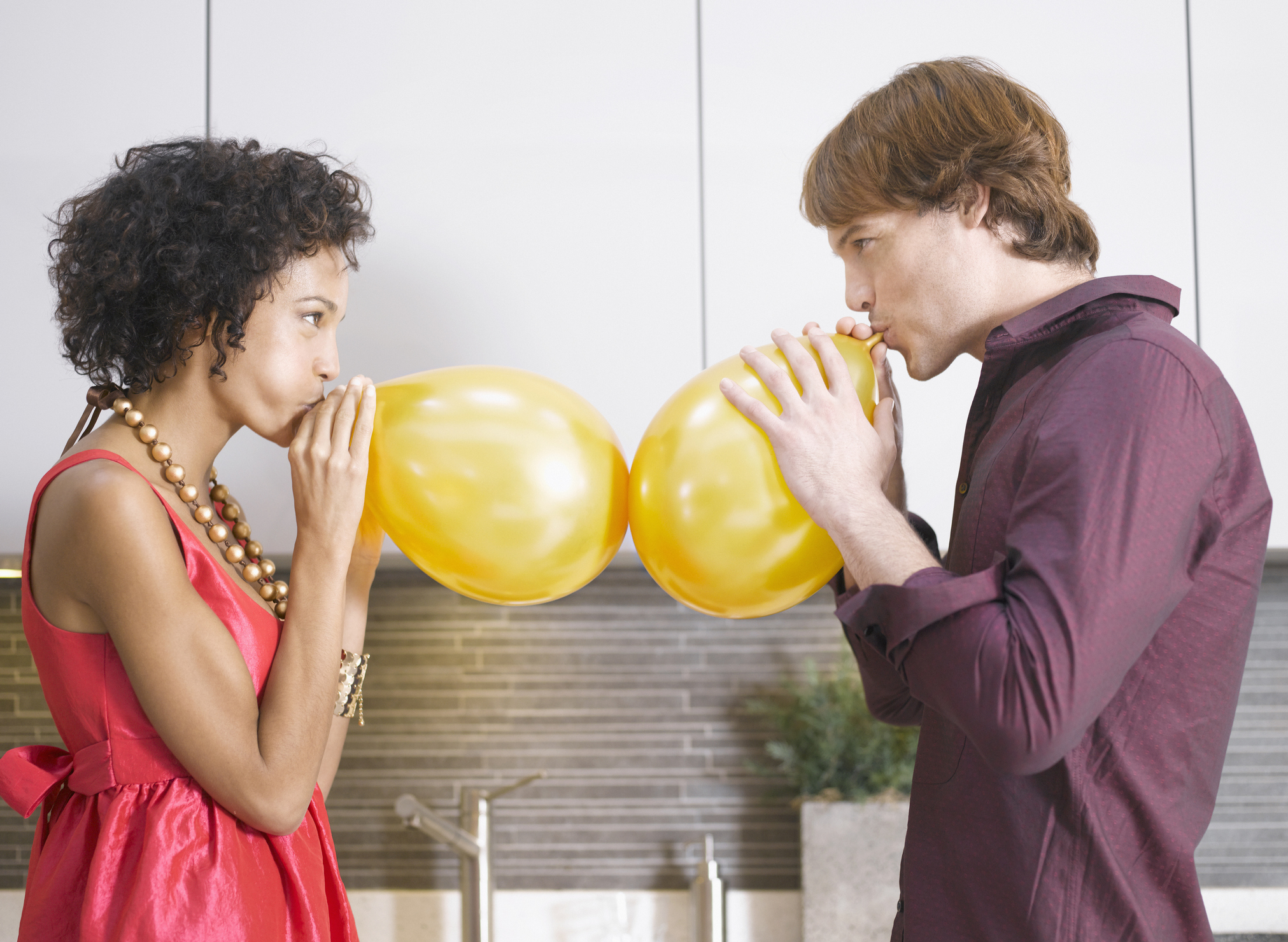 Couple blowing up balloons