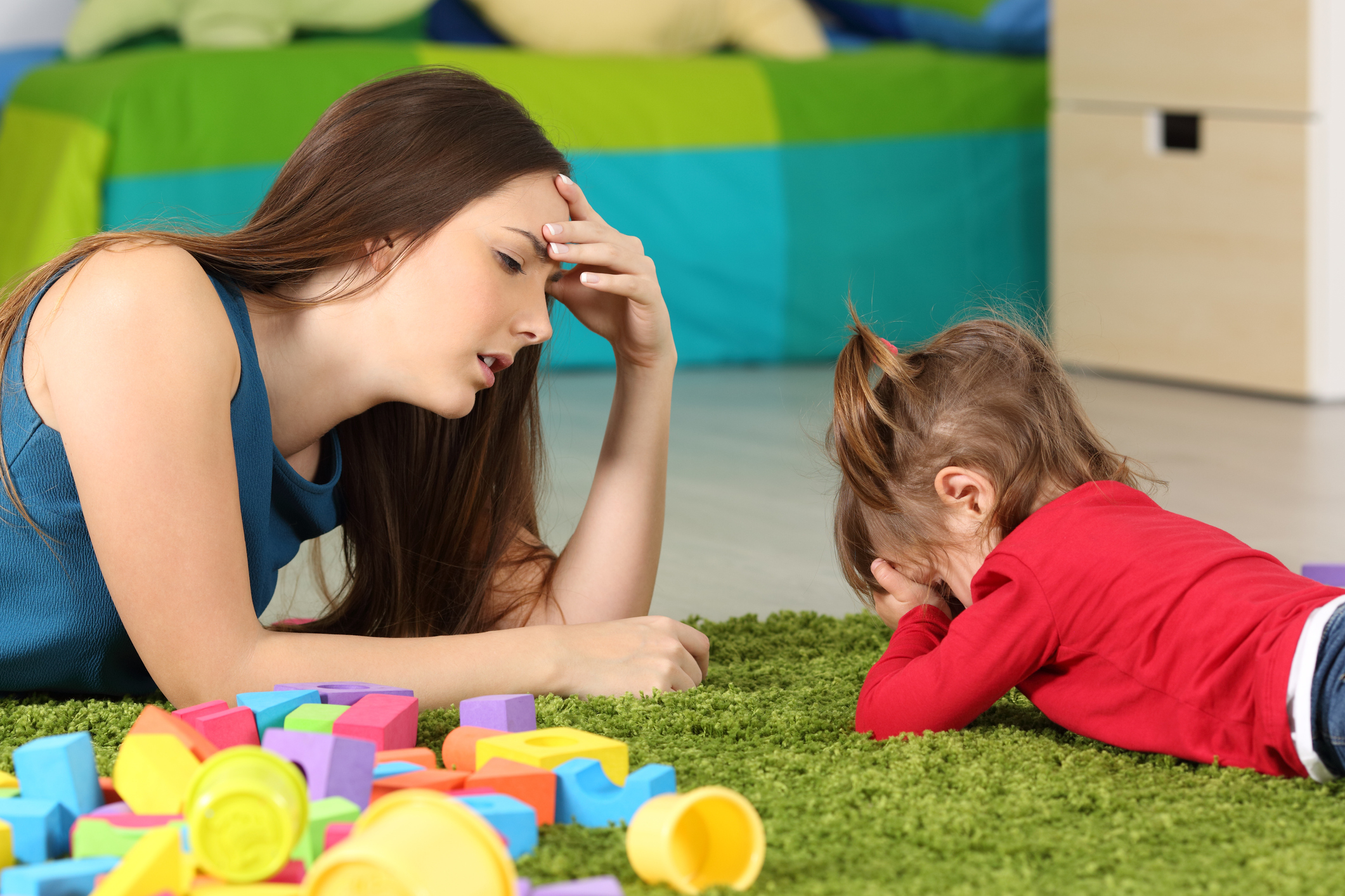 Angry baby and tired mother in a room