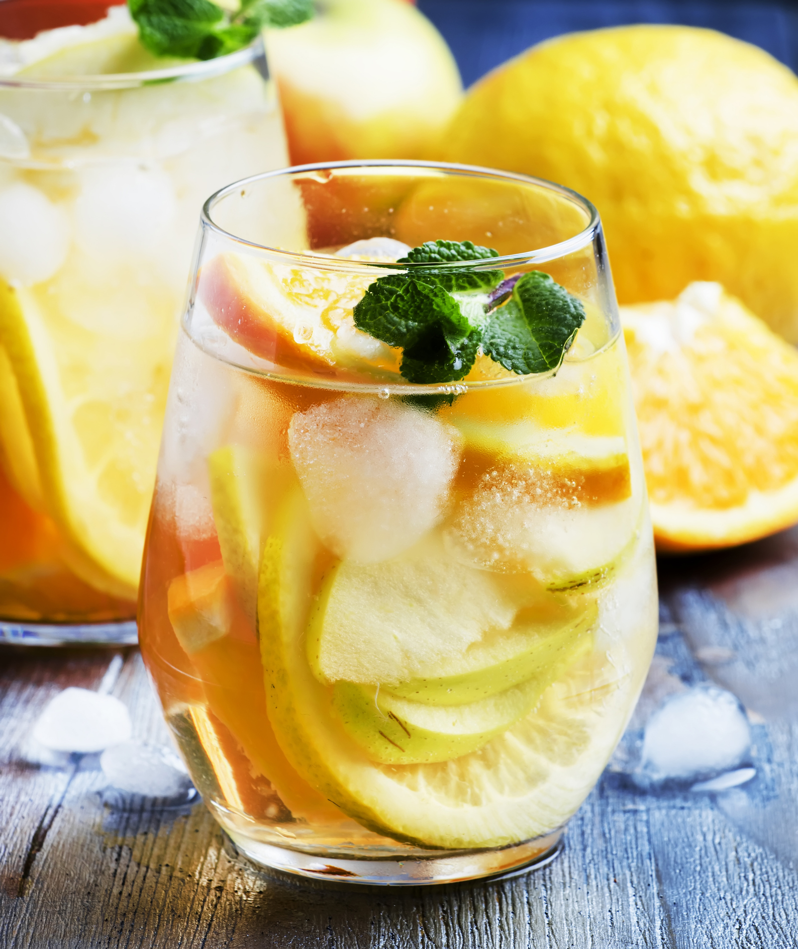 White citrus sangria in glass on gray background