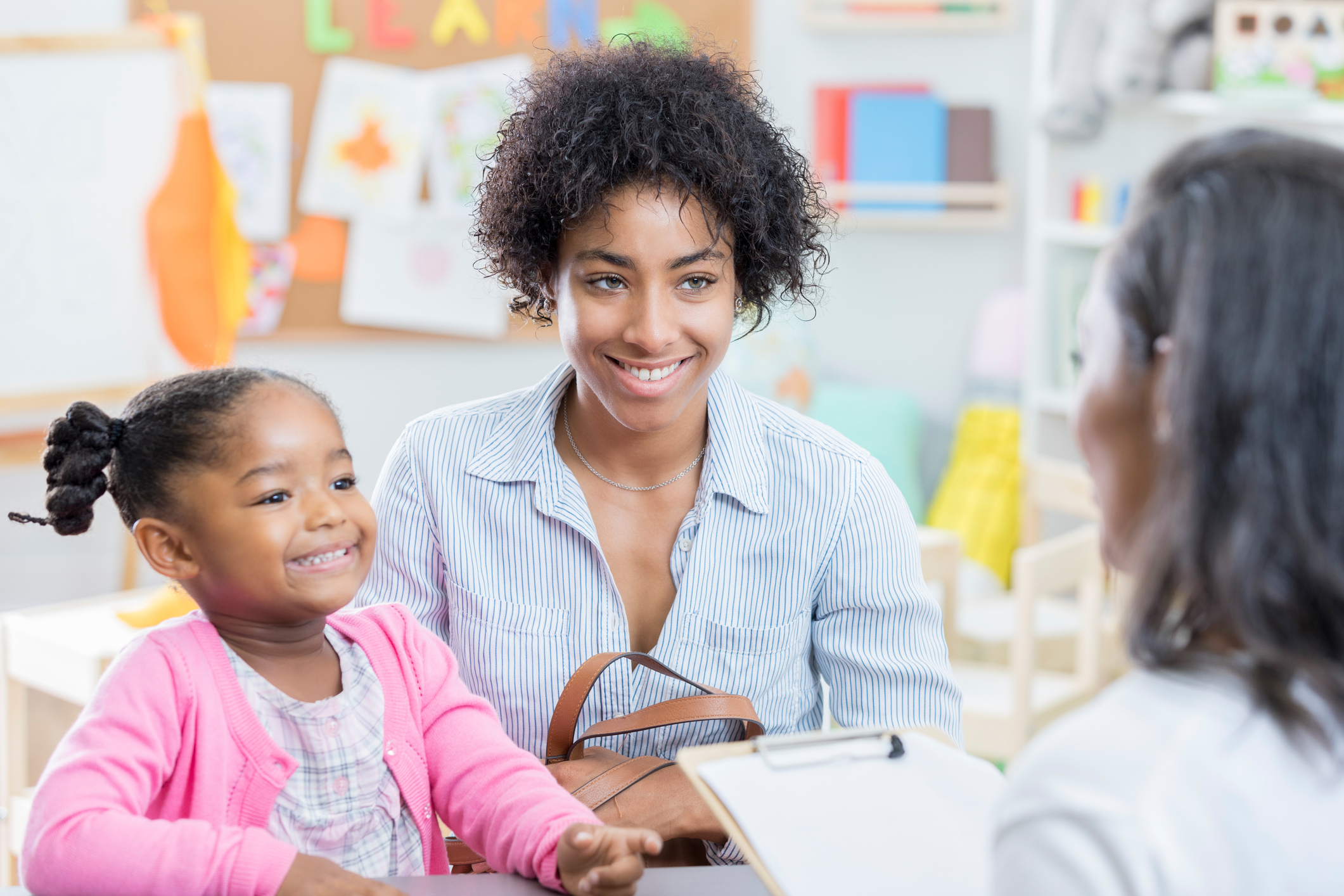 African American mom talks with teacher during conference