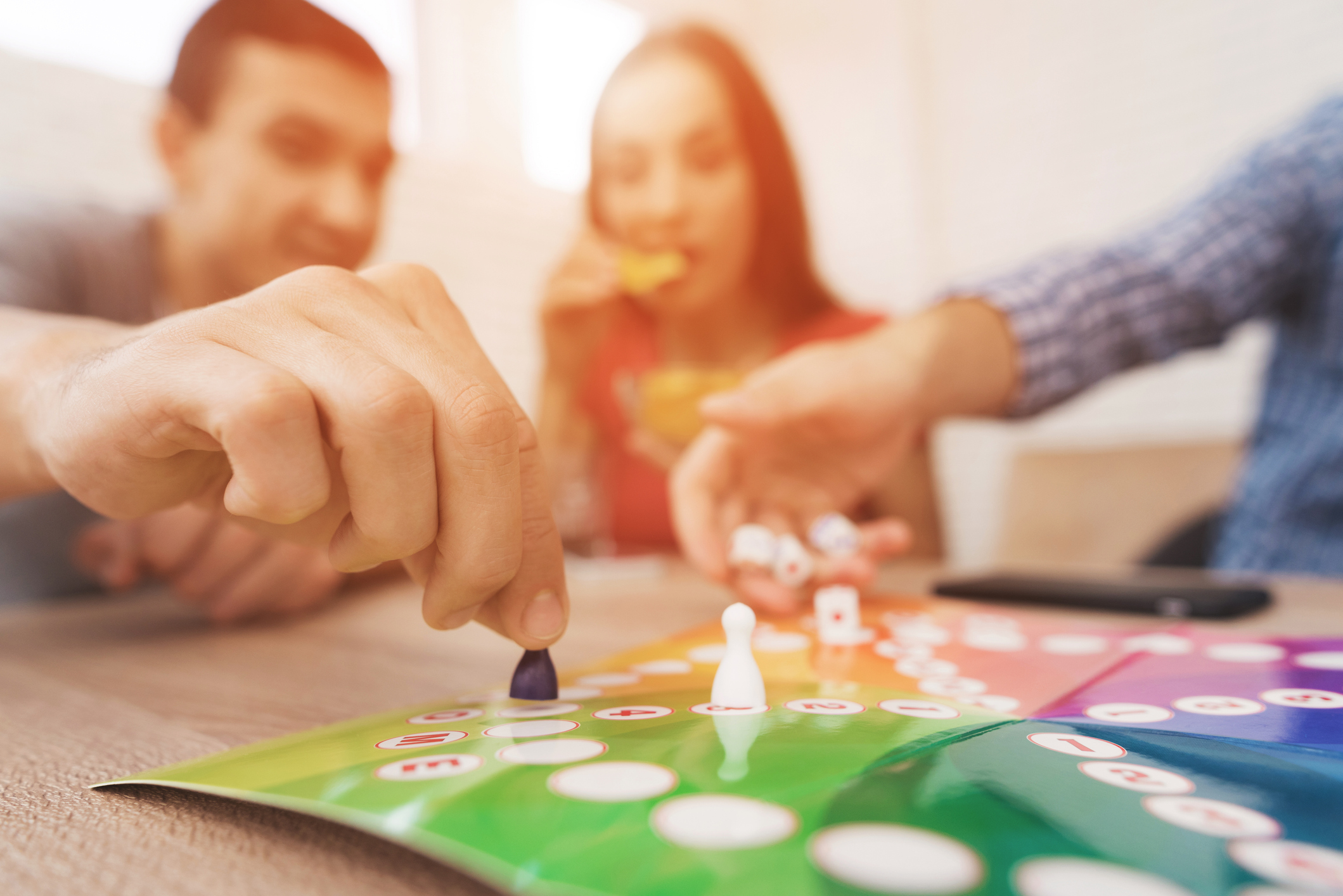 Young people play a board game using a dice and chips.