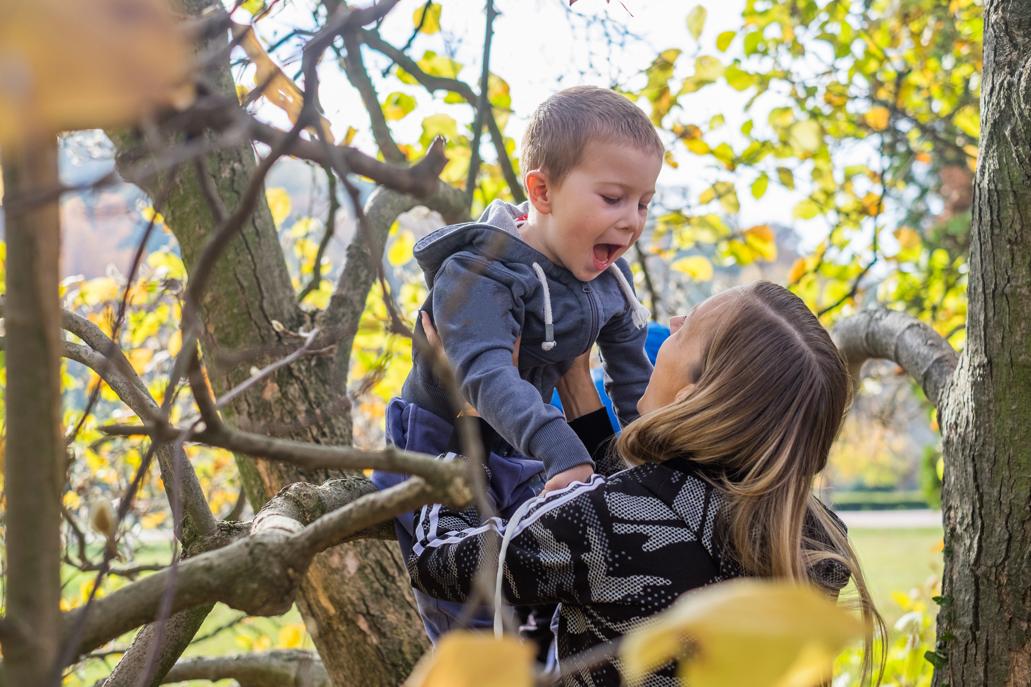 Mother holding son on branch