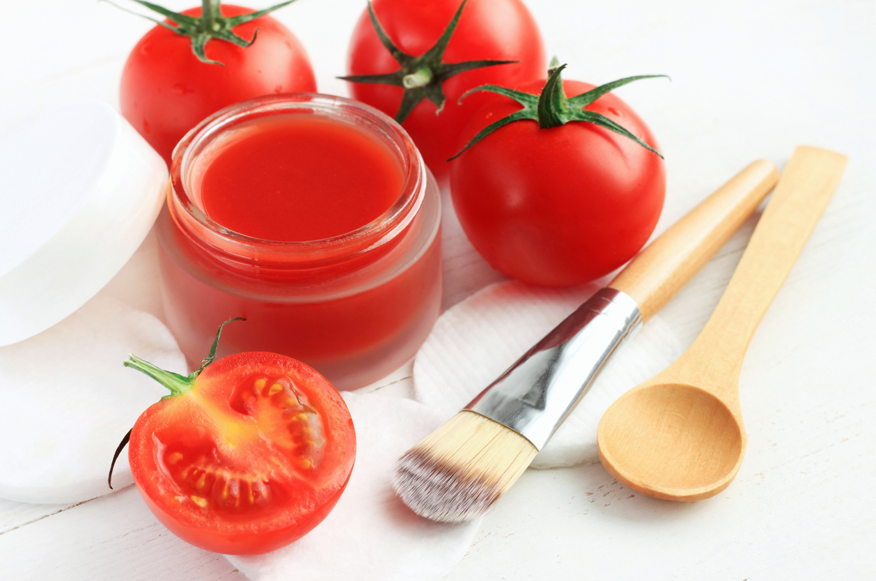 Cosmetic jar of facial homemade mask from bright red fresh ripe tomatoes, closeup.