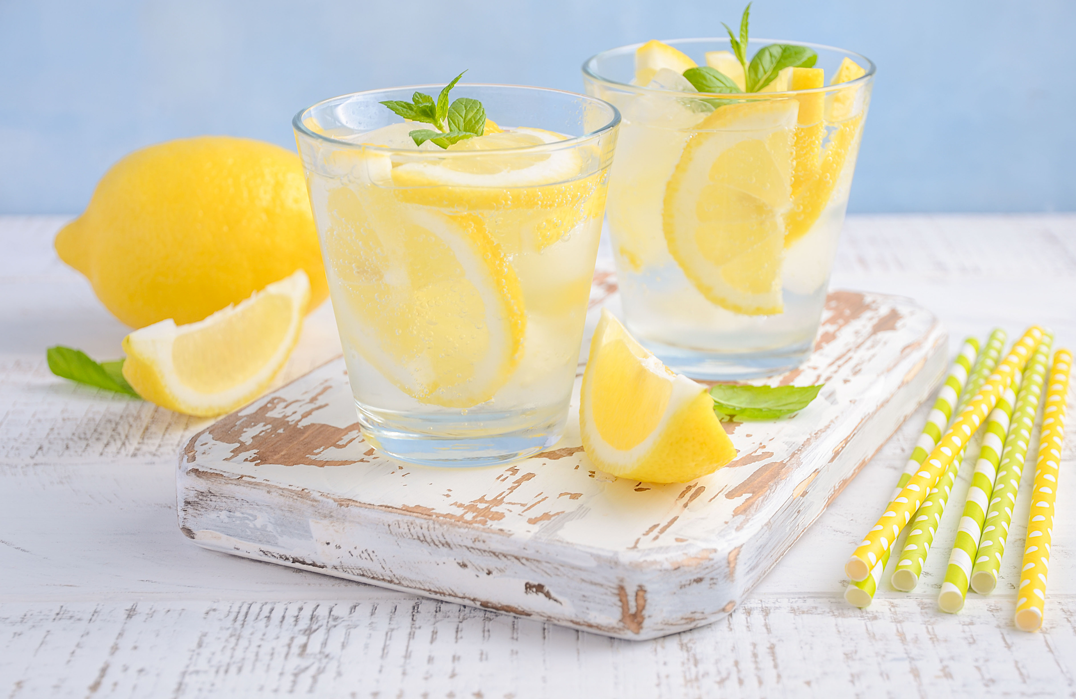 Cold refreshing summer drink with lemon and mint on wooden background.