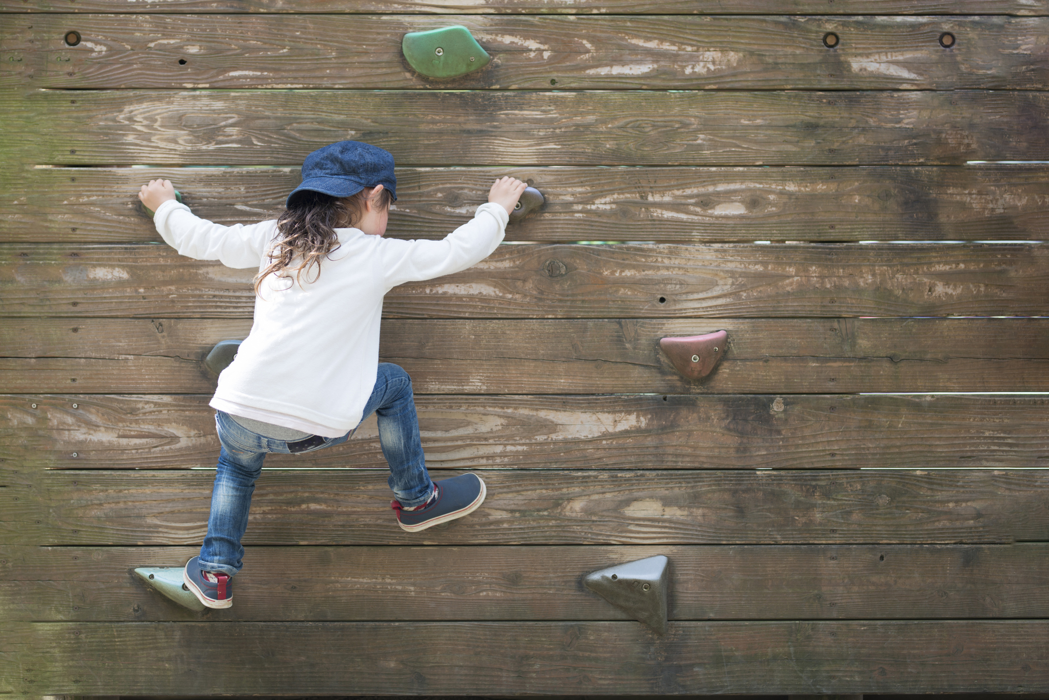 Little girl climbing the wall