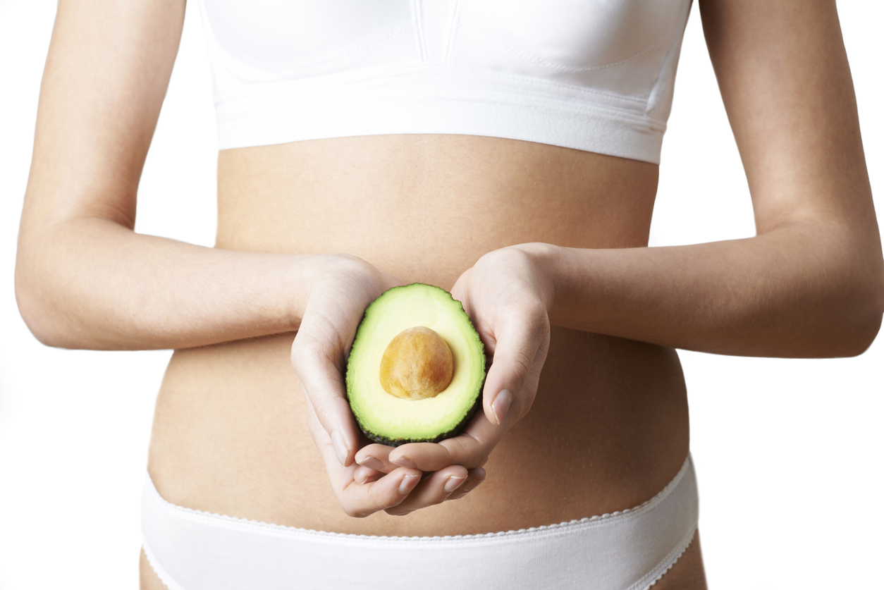 Close Up Of Woman In Underwear Holding Halved Avocado