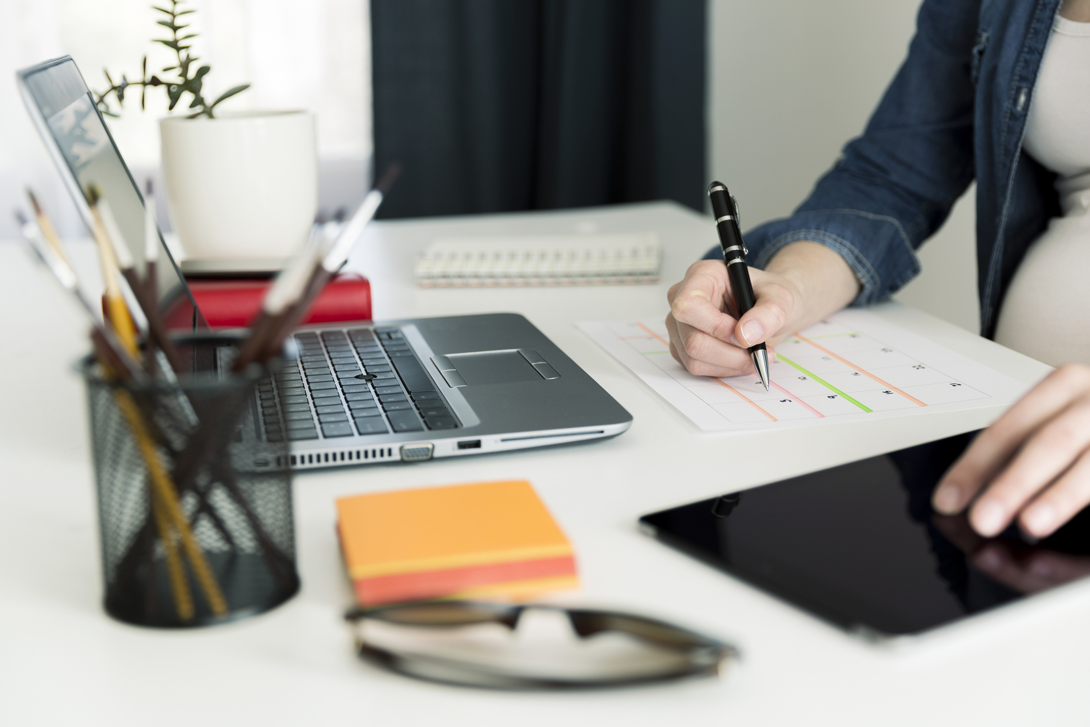 Calendar planner agenda schedule concept. Woman working in her office, working, planning. Maternity leave planning