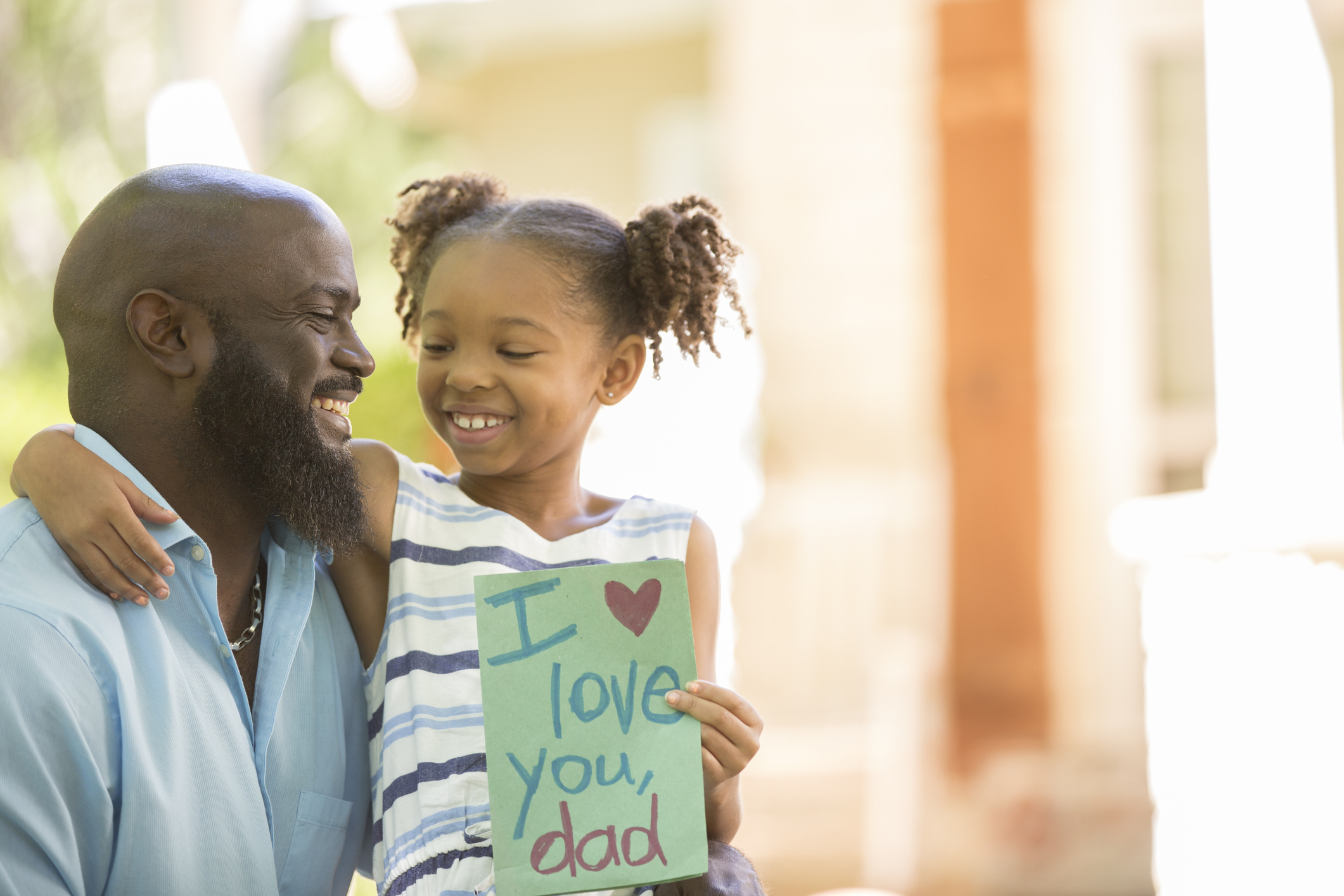 Happy Father's Day. Girl gives card to dad.