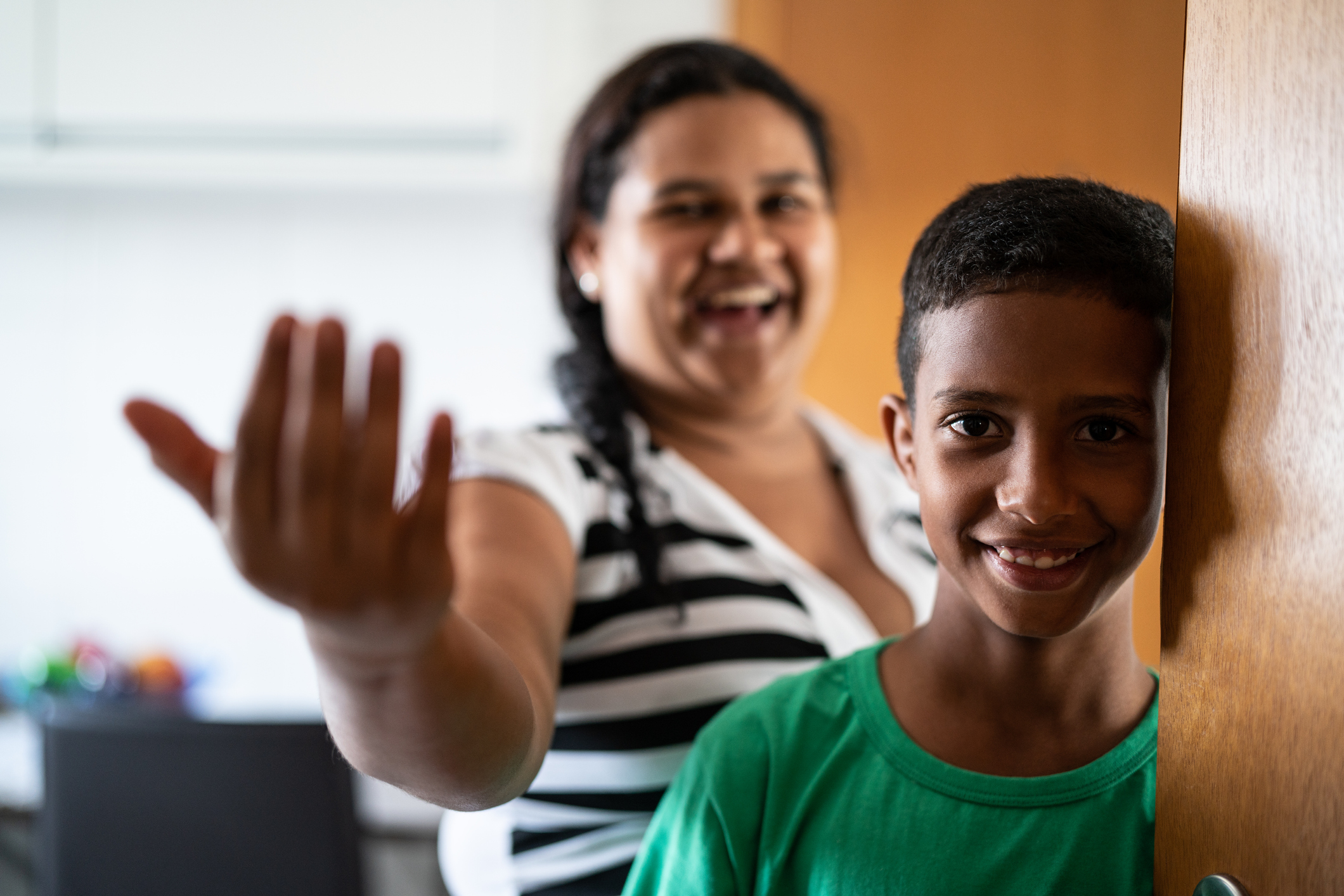 Mother and son welcoming and opening door