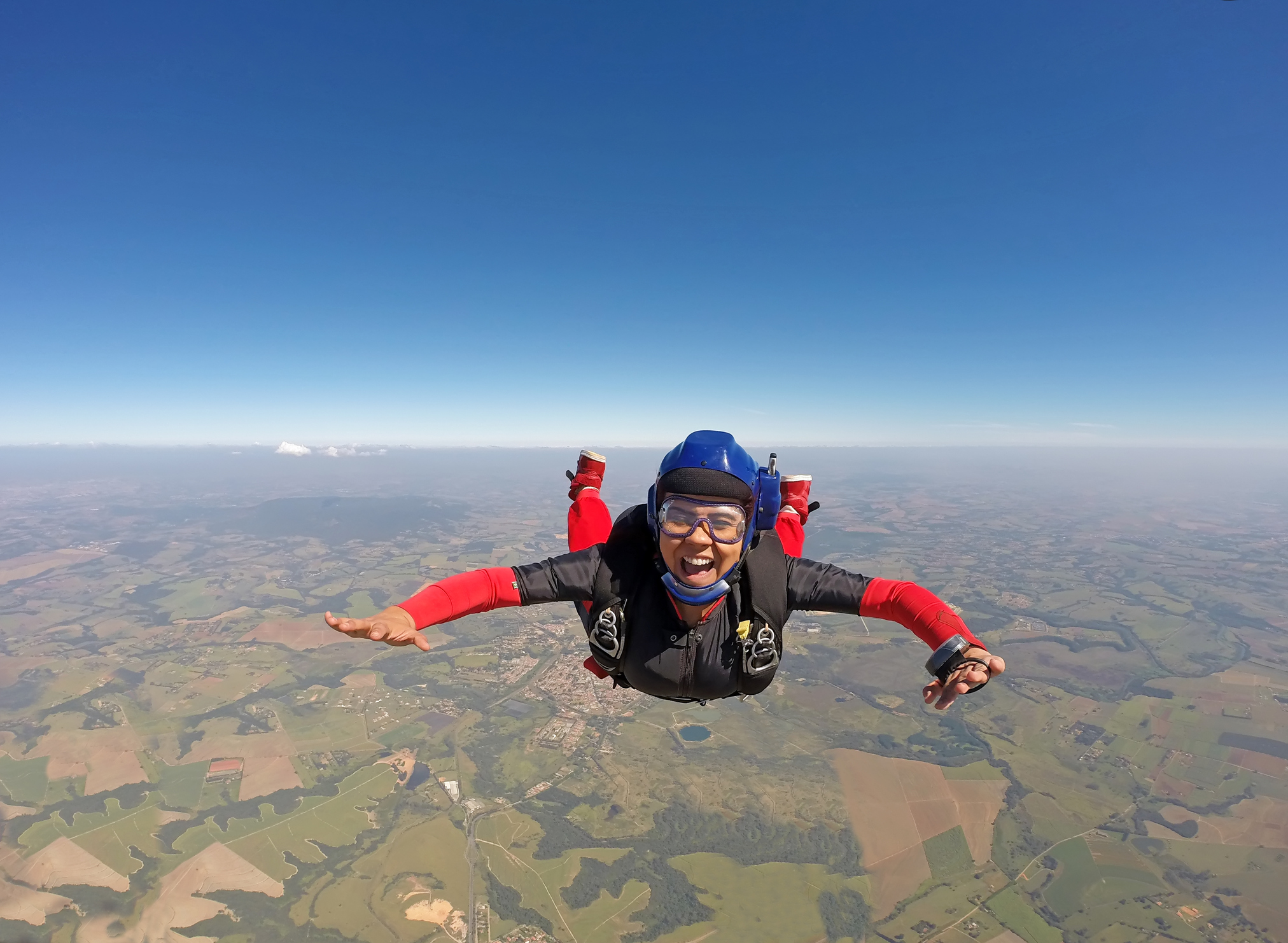 Smiling black woman jumping from parachute