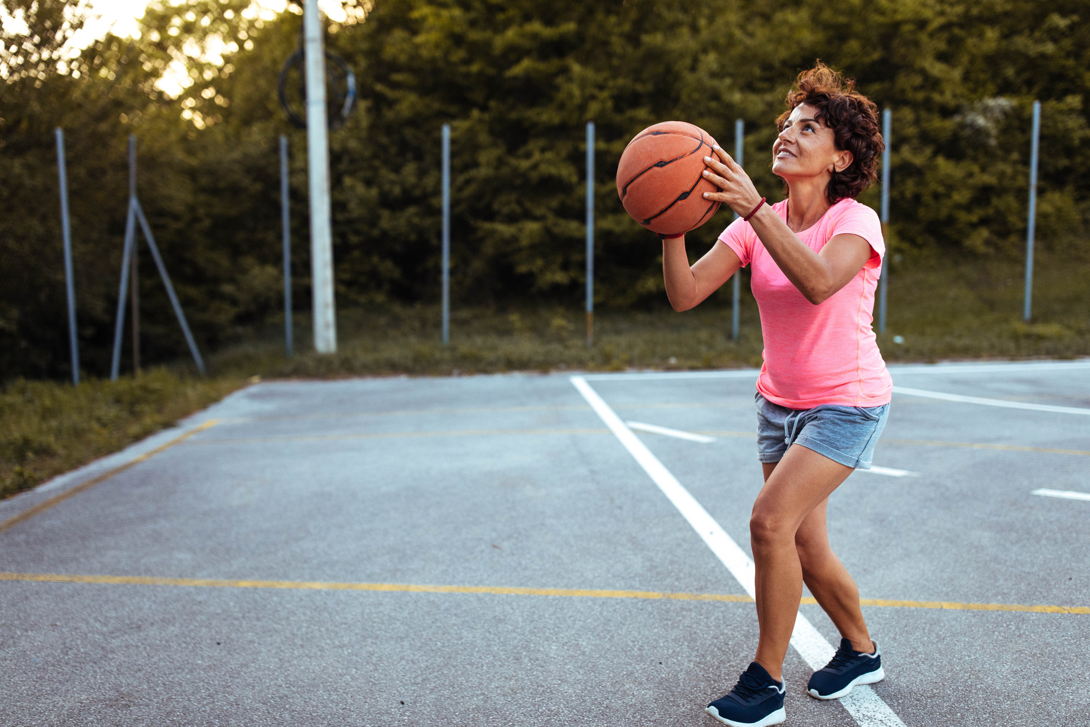 Mature woman playing basketball