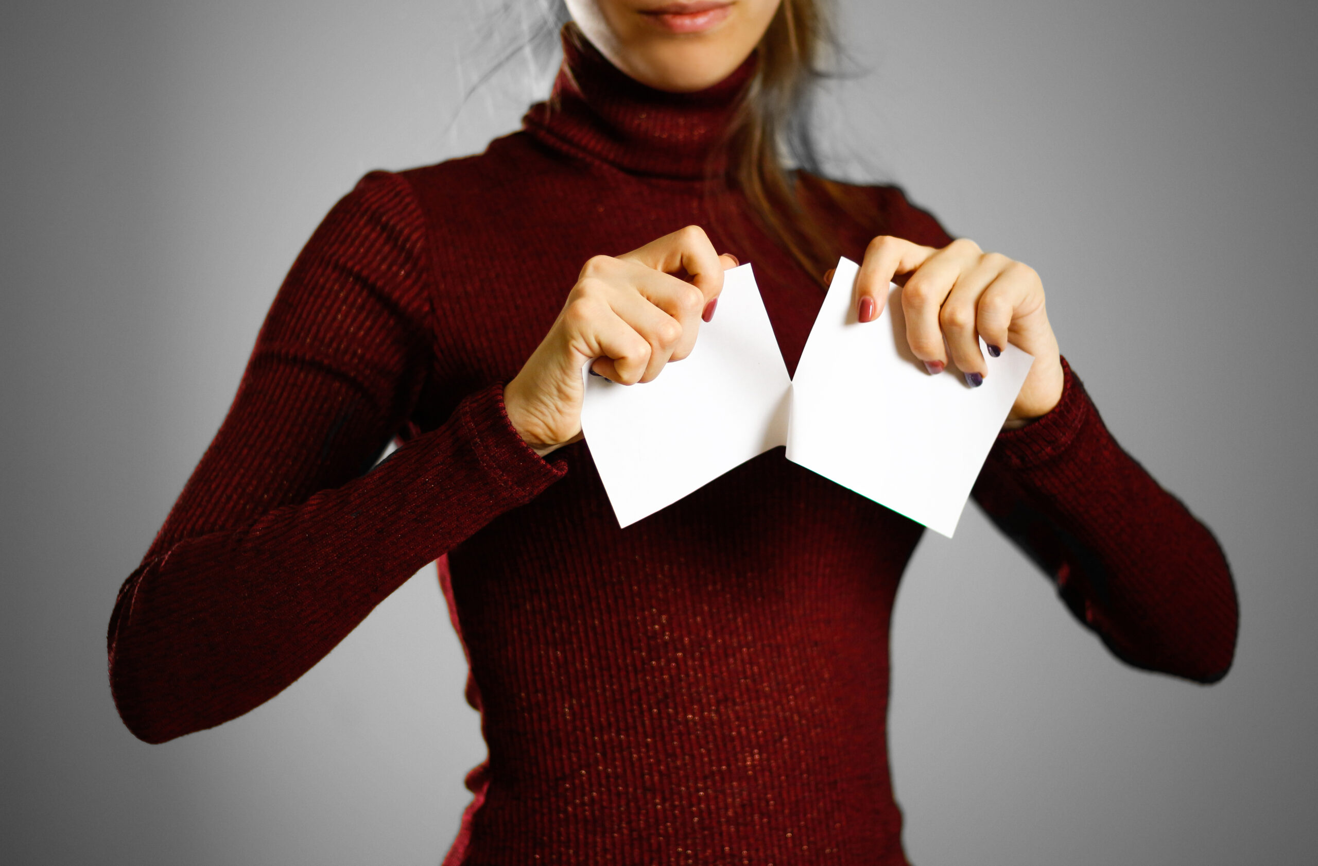 Girl tearing a piece of paper in half blank white flyer brochure booklet. Leaflet presentation