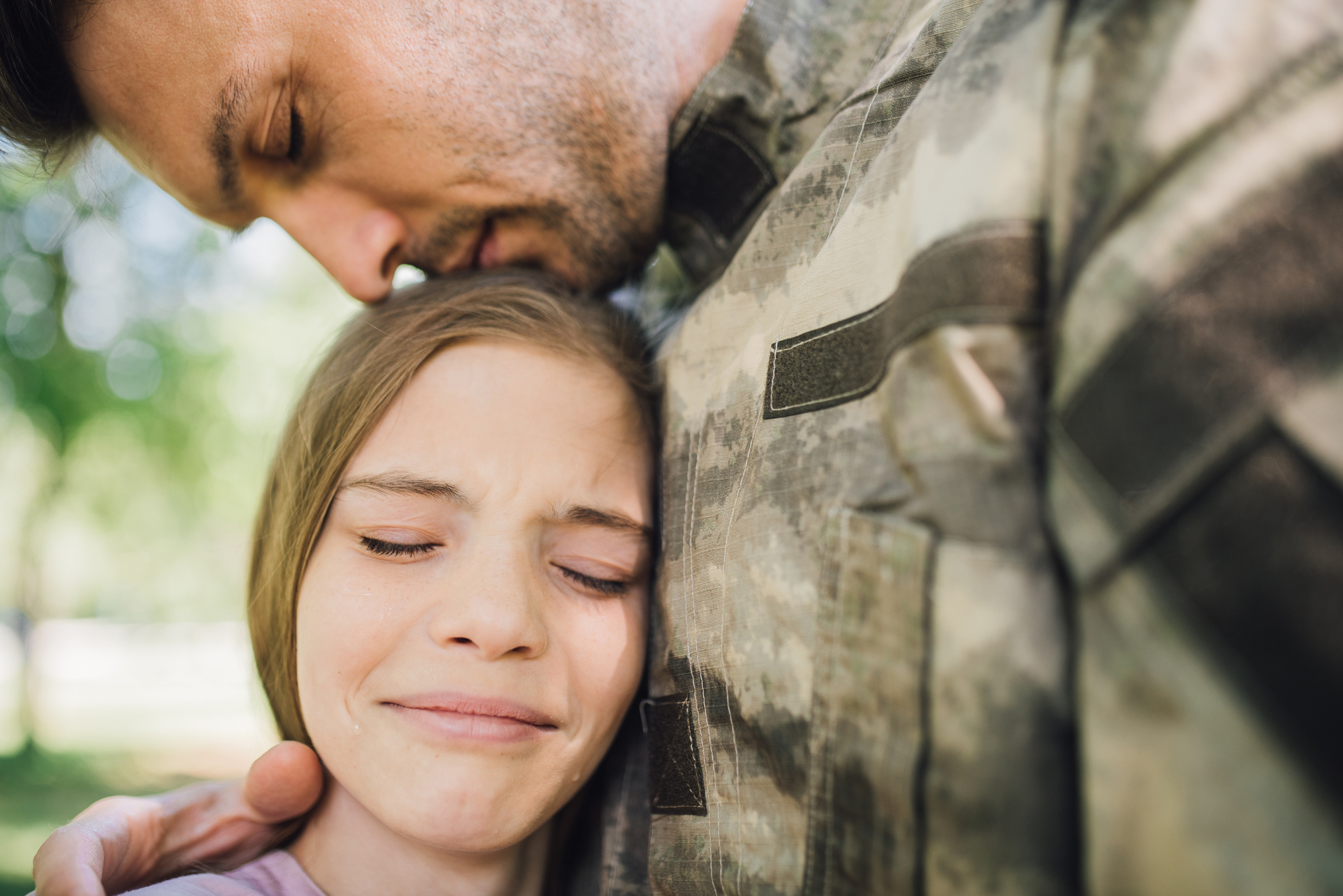 Soldier leaning onto his sad daughter in emotion