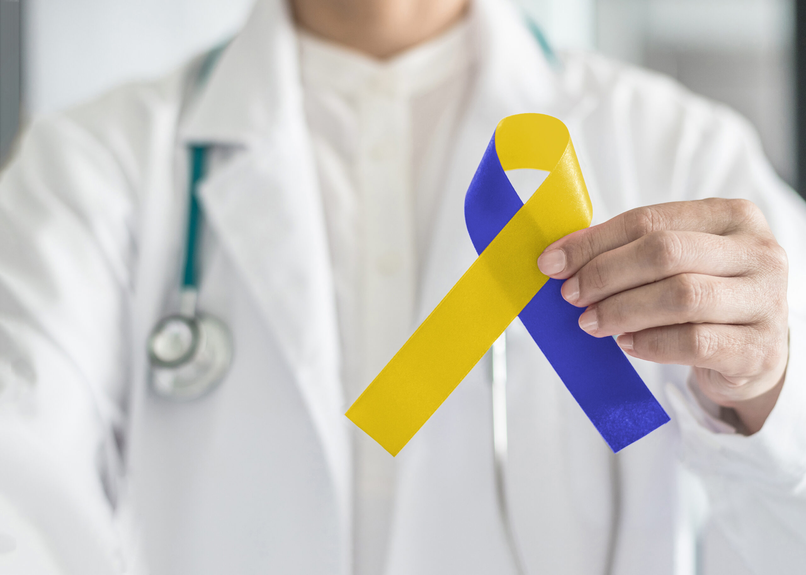 World down syndrome day blue yellow awareness ribbon on doctor's hand for raising support on patient with down syndrome illness disability and Thoracic Outlet Syndrome - (TOS)