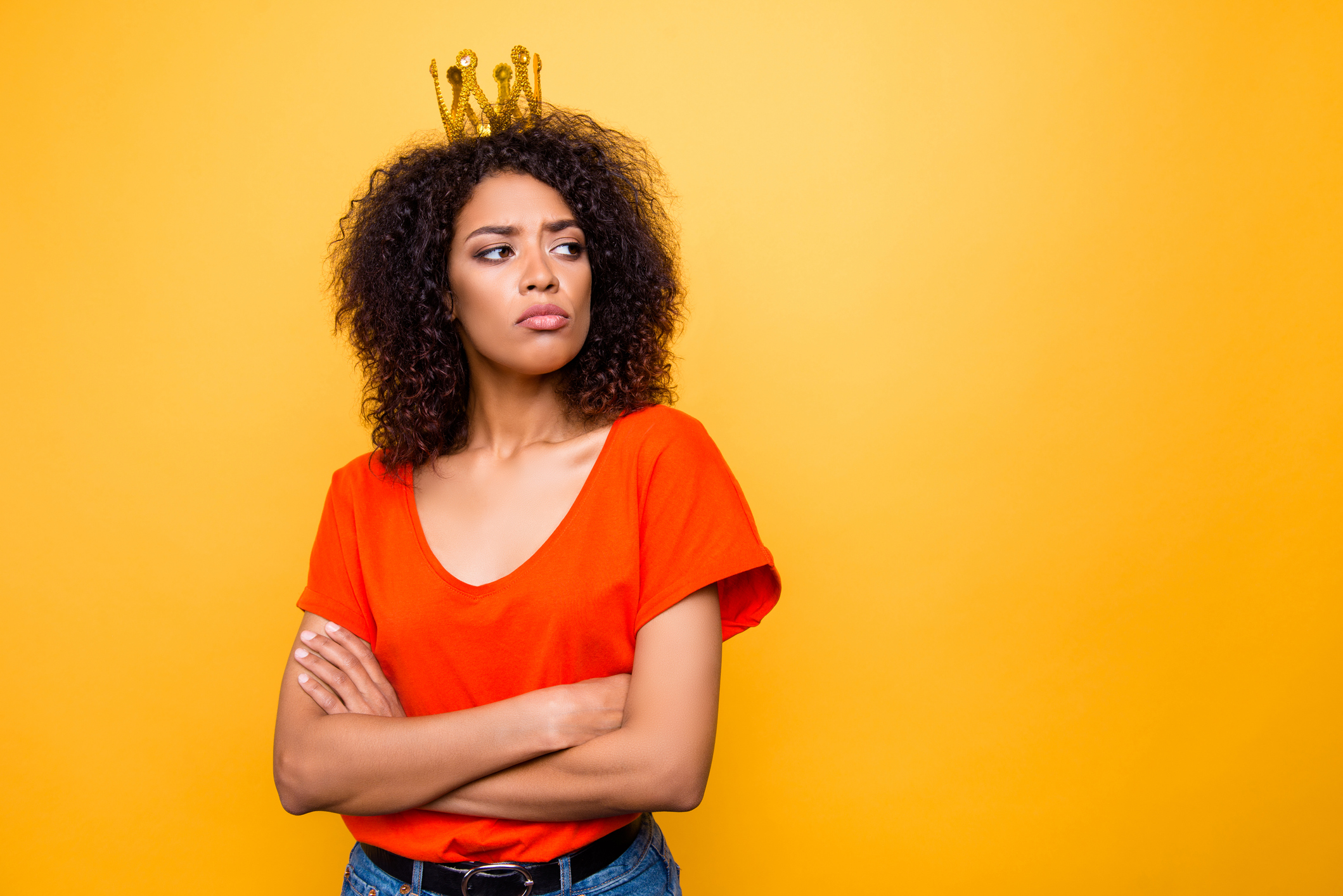 Portrait with copy-space empty place for advertisement of proud arrogant woman with modern hairdo holding arms crossed looking at empty place with offensive expression isolated on yellow background