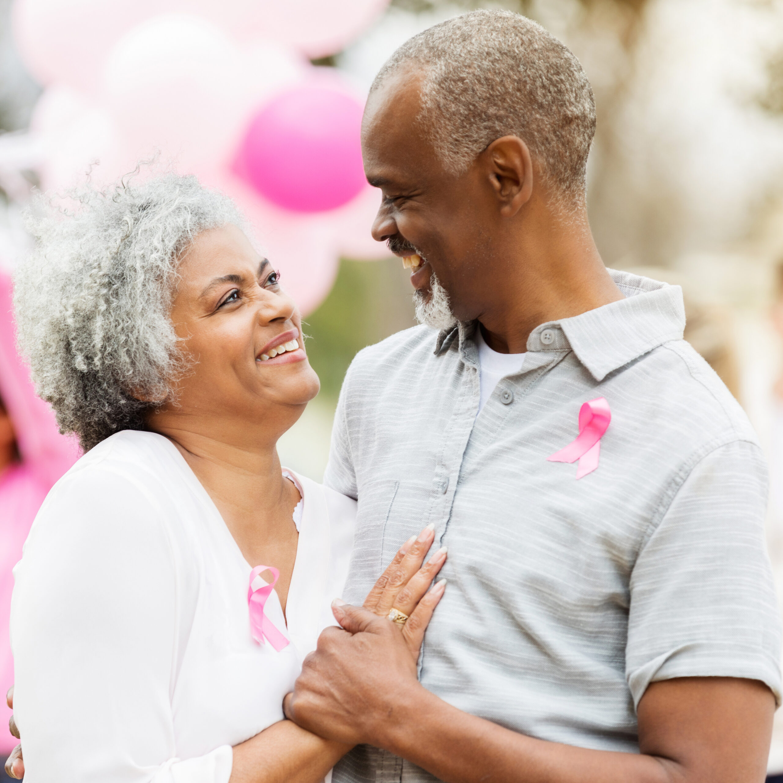 Confident senior couple during cancer awareness event