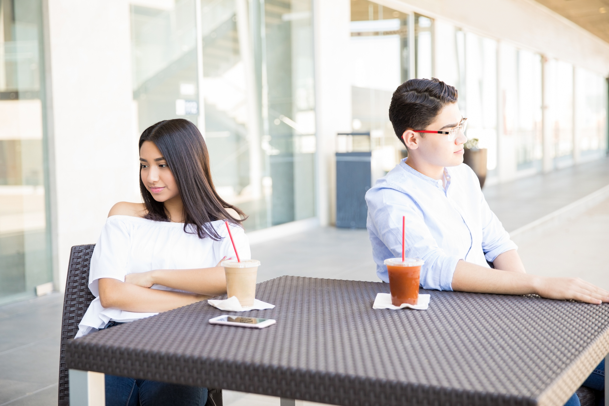 Teenage Couple Having Quarrel At Table In Mall