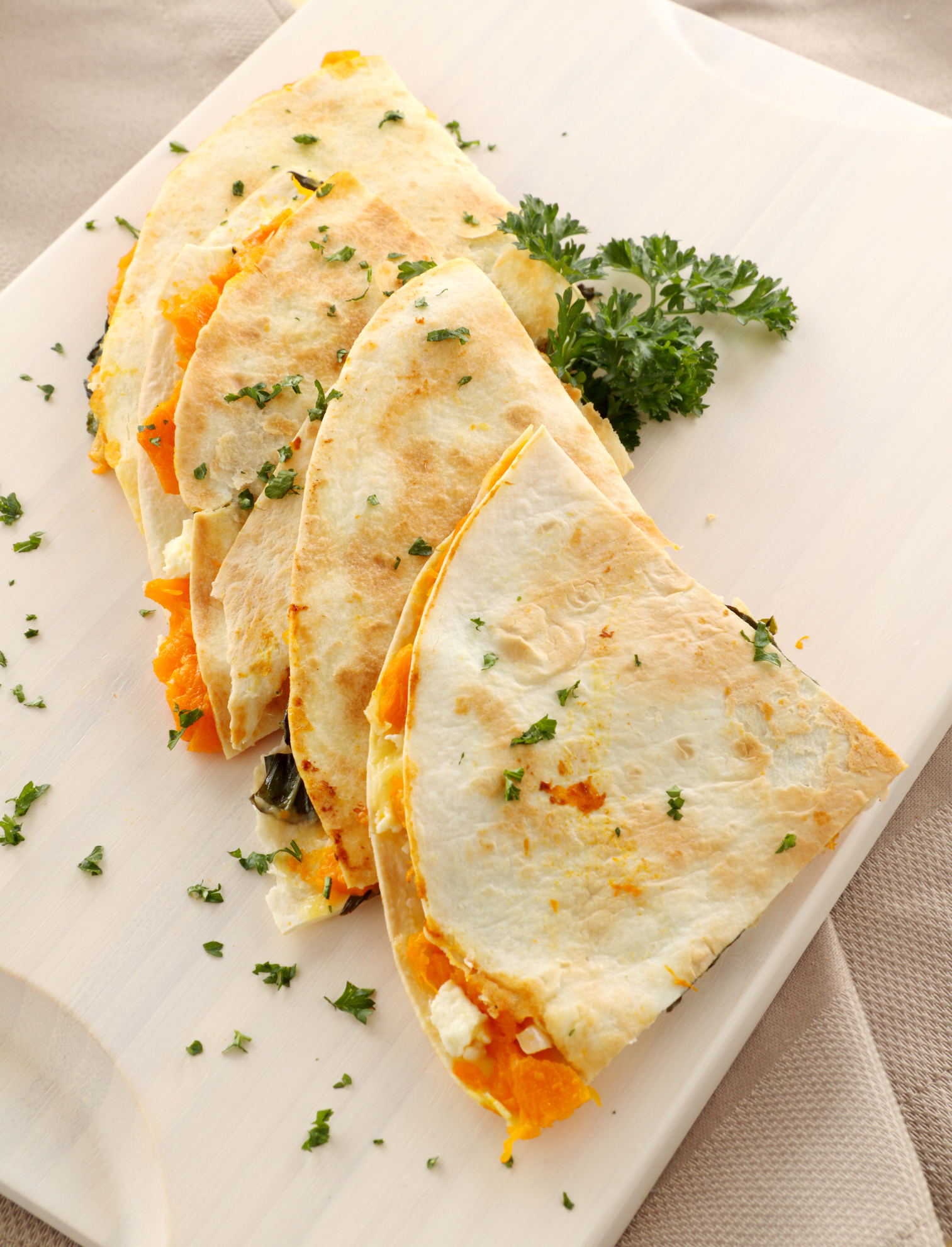 Toasted pumpkin quesadillas on white wooden board