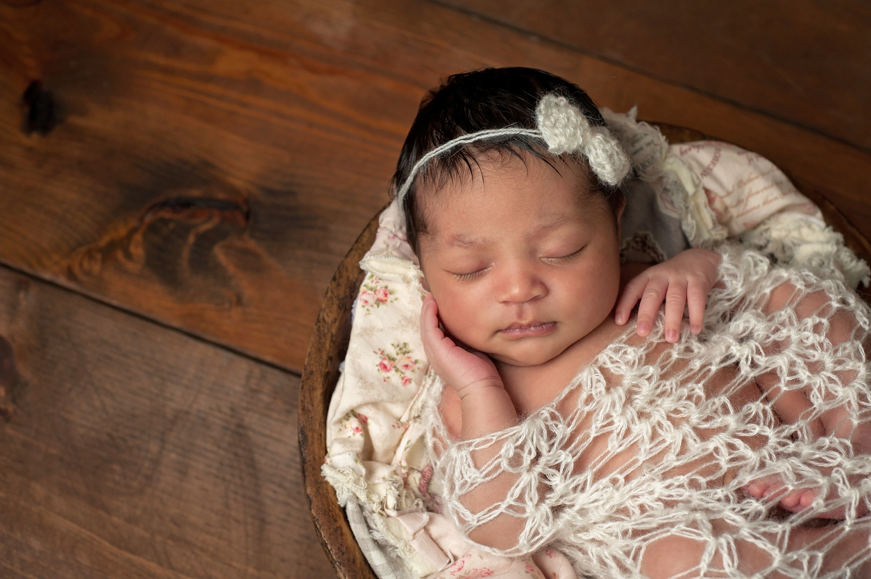 Newborn Girl Sleeping in Wooden Bowl