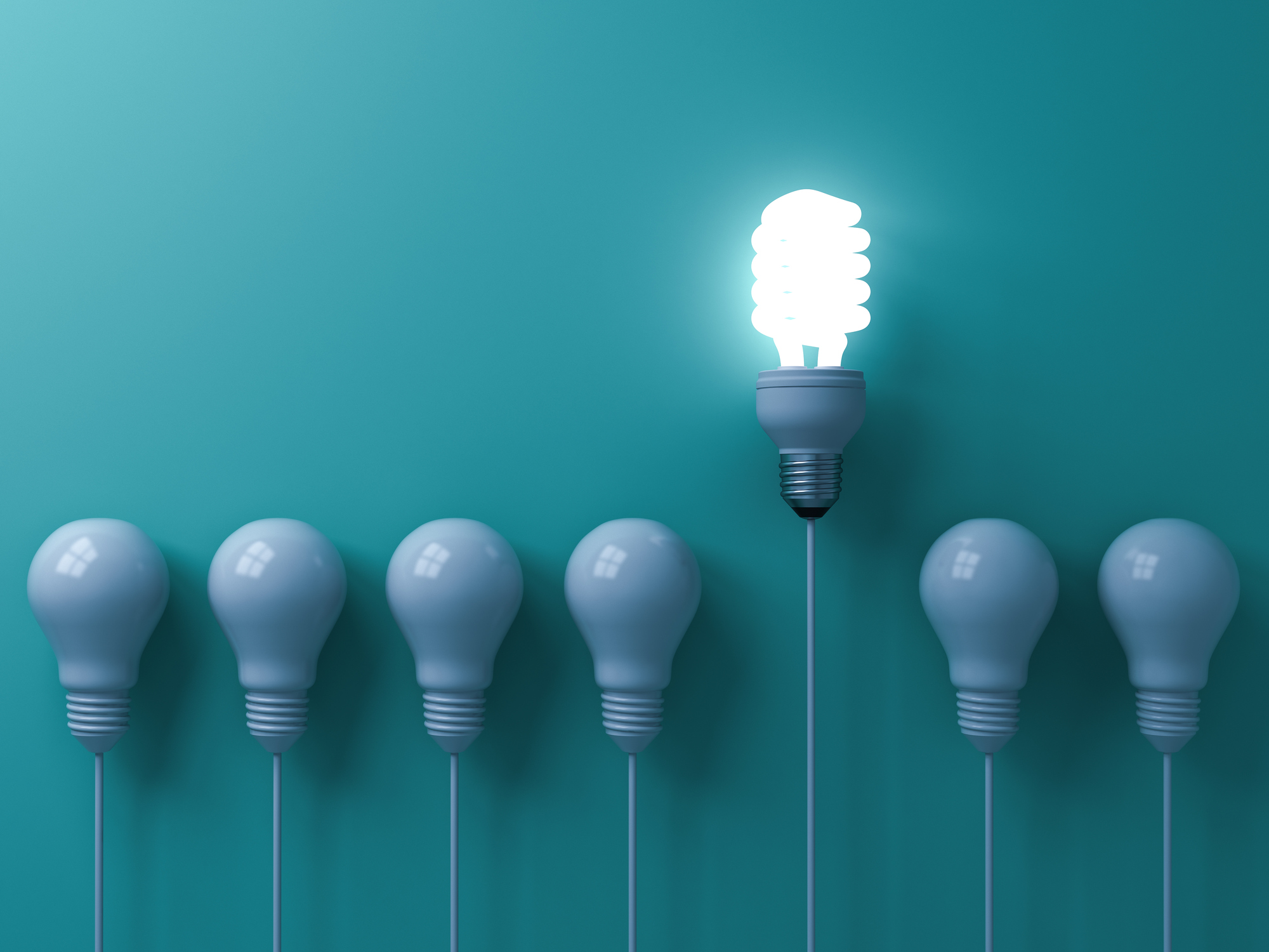 One eco energy saving light bulb glowing and standing out from unlit incandescent white bulbs on green pastel color wall background  leadership and different creative idea concepts 3D rendering