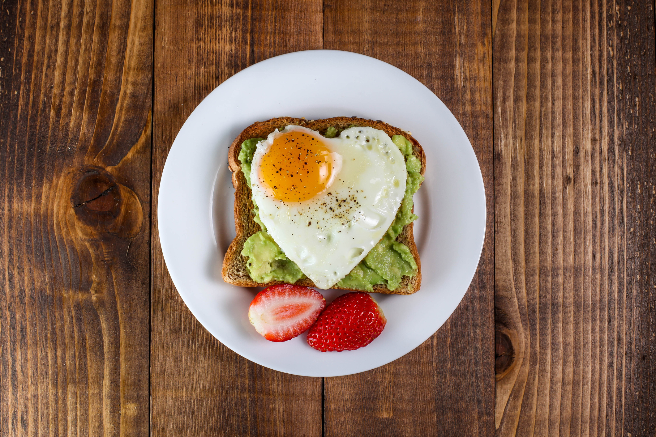 Toast with avocado and egg in heart shape