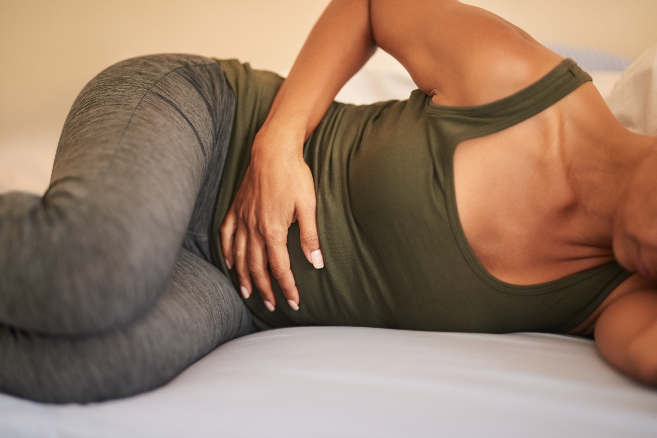 Shot of a woman suffering from stomach ache on bed