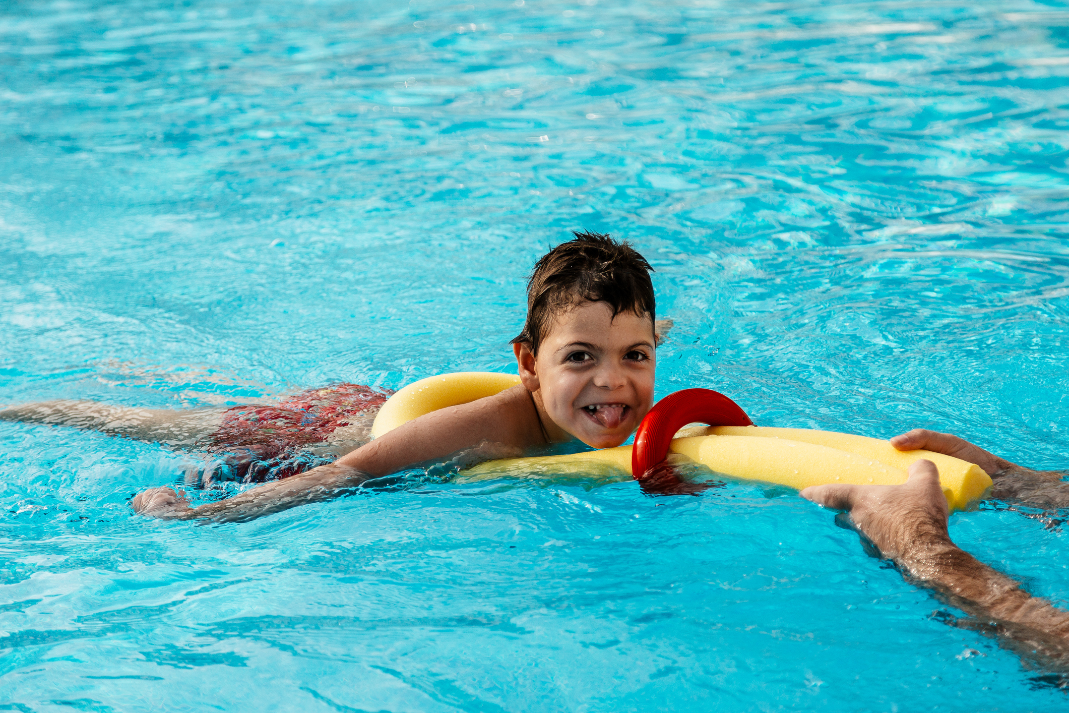 little boy playing in pool with float