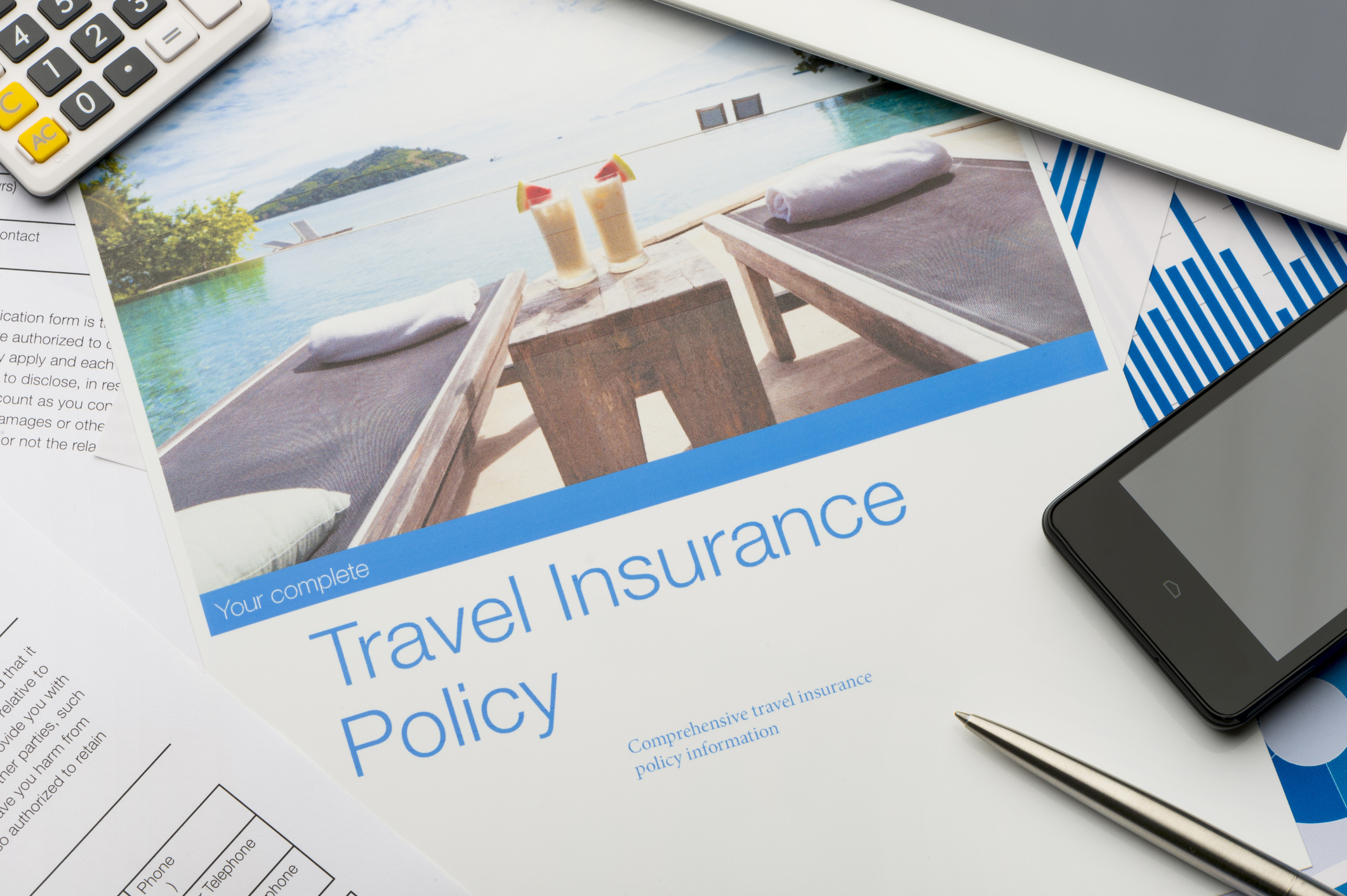 Travel insurance policy document with paperwork and technology.