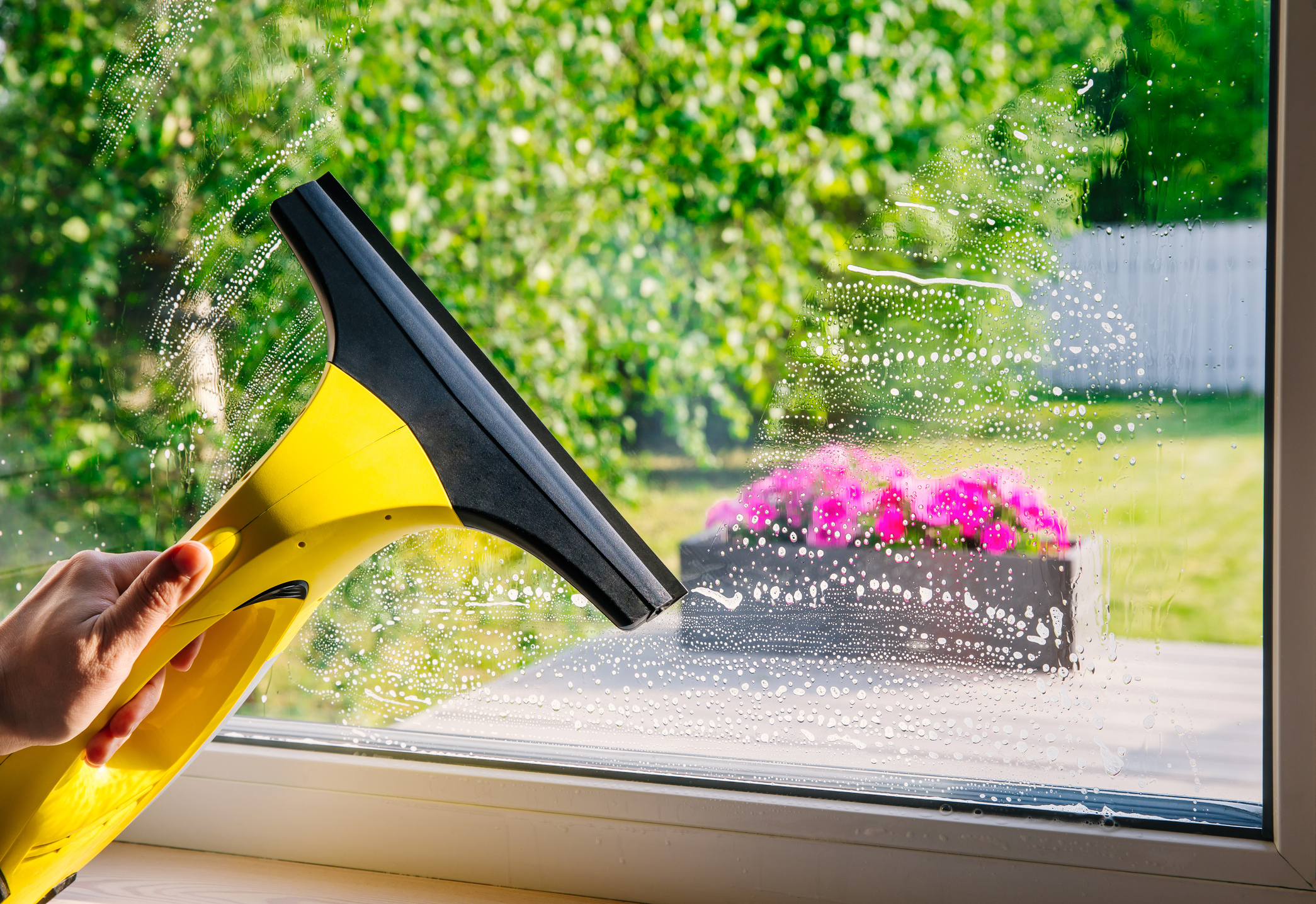 Cleaning windows with portable professional vacuum cleaner.