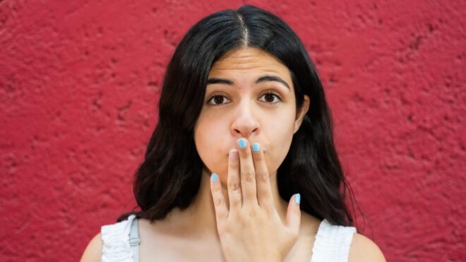 Young latina covering her mouth