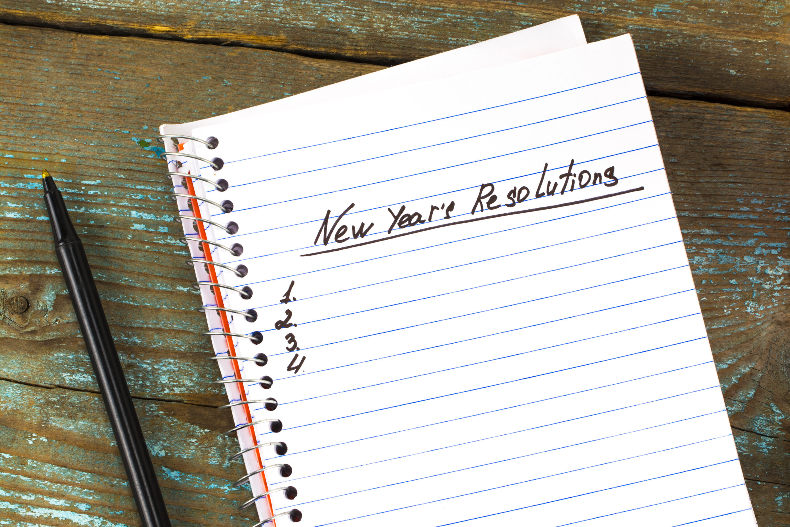 New Year's Resolution written on a notepad and pen. New Year resolutions concept