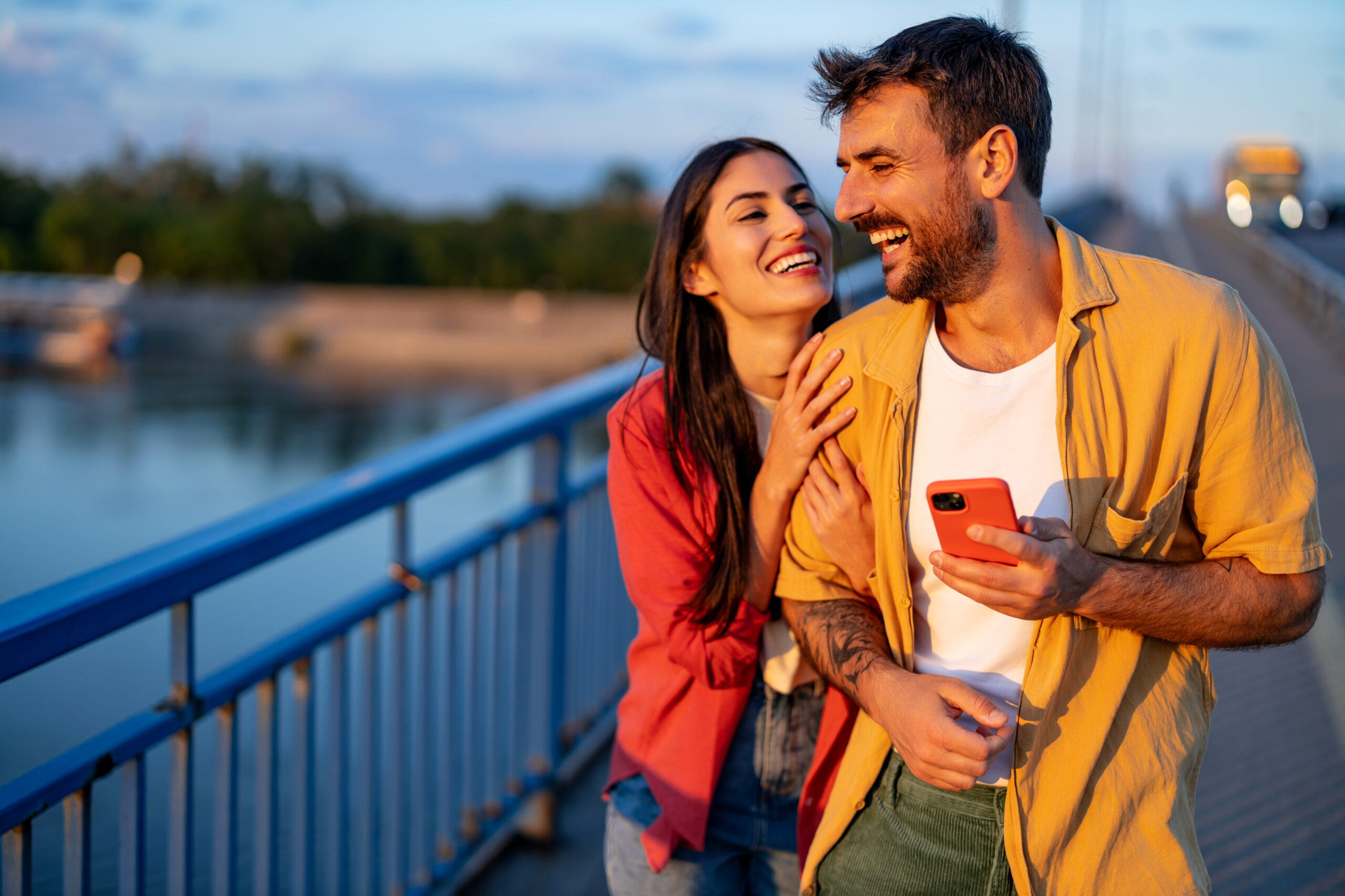 Couple walking across a bridge at sunset