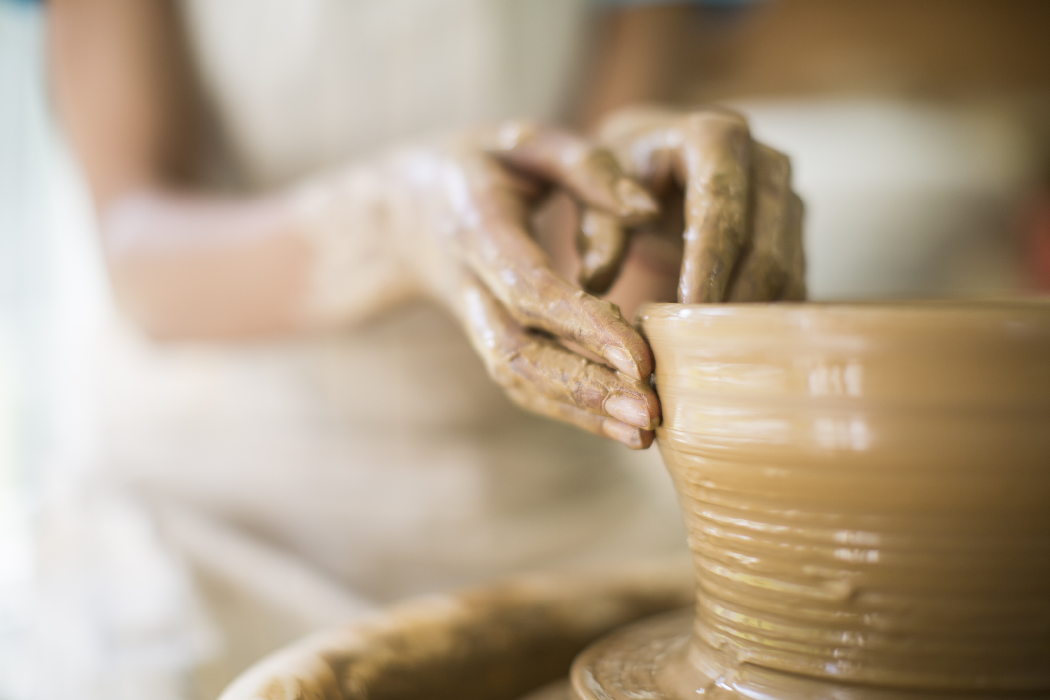 Close up of female potter's hands making bowl