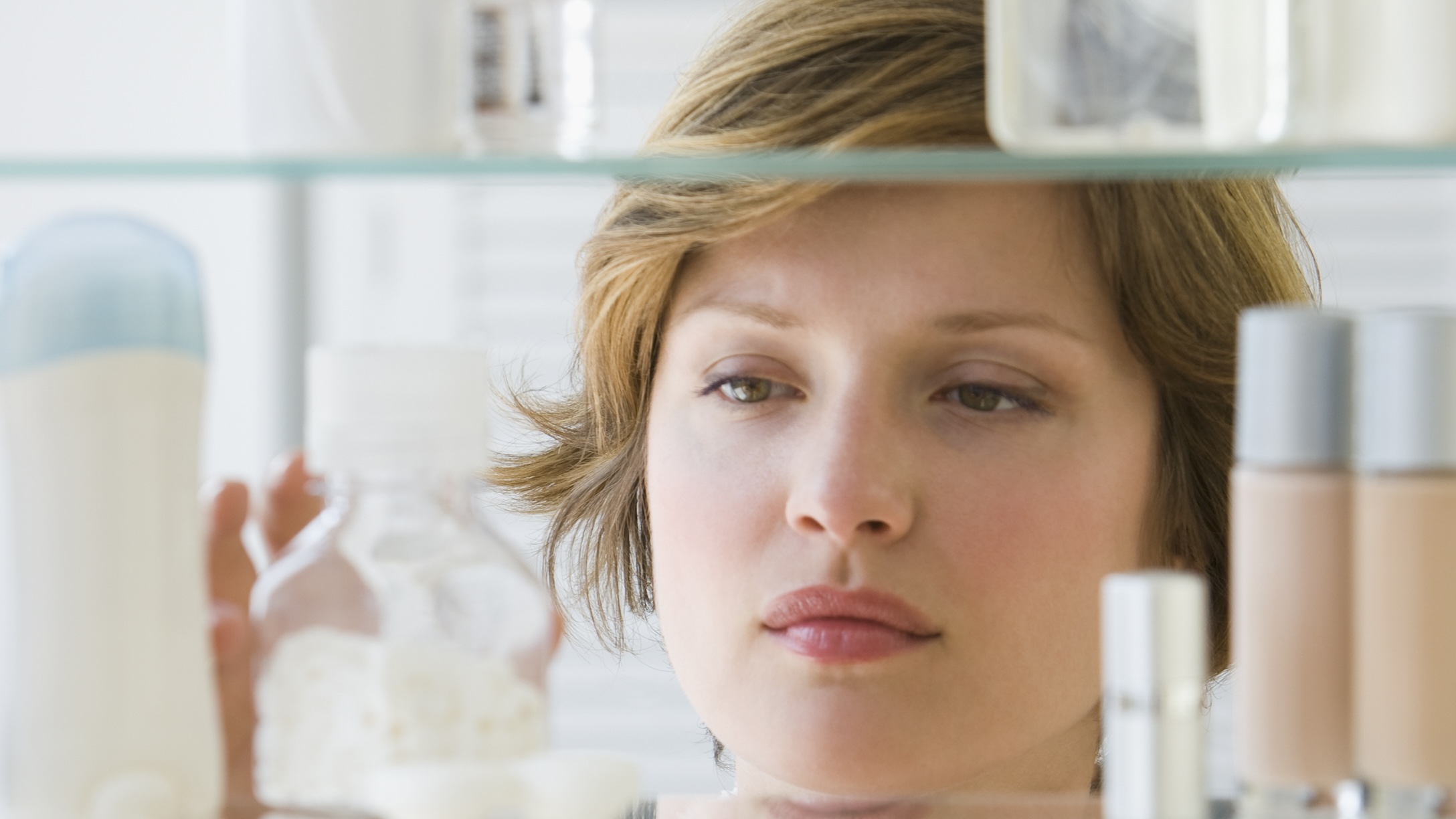 Woman looking in medicine cabinet