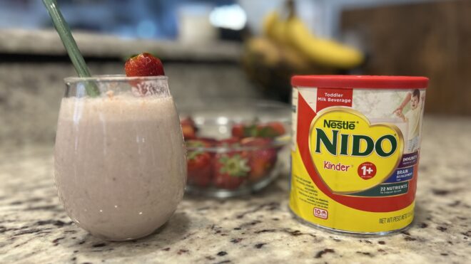 smoothie in a glass with strawberries in the background